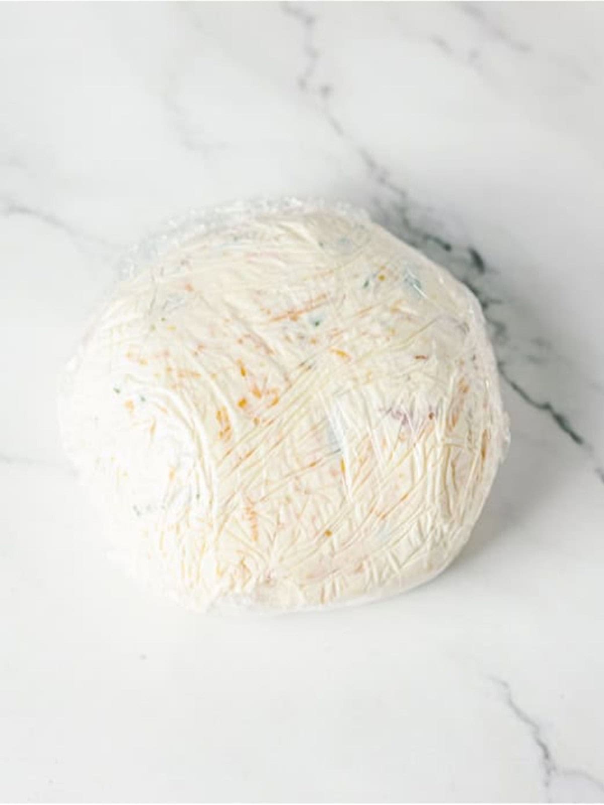 Cheese ball shaped into a round ball ready to chill.