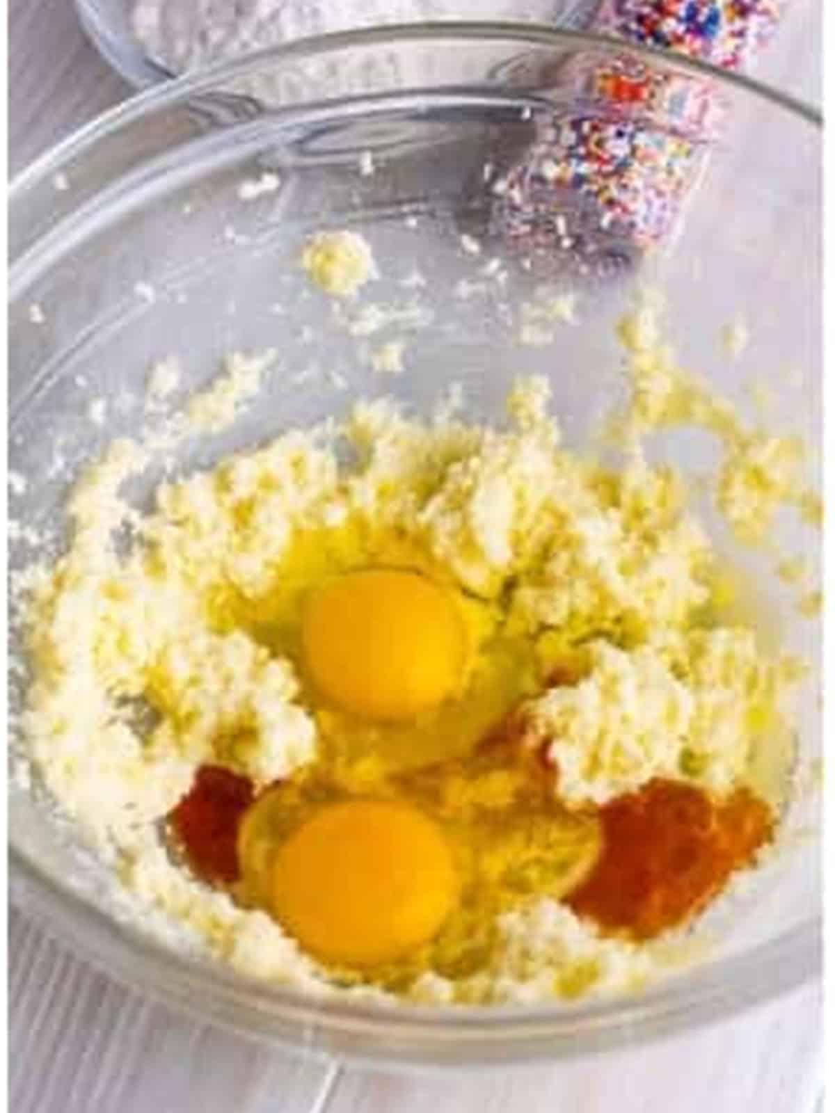 Adding eggs and vanilla to the fairy cake batter.