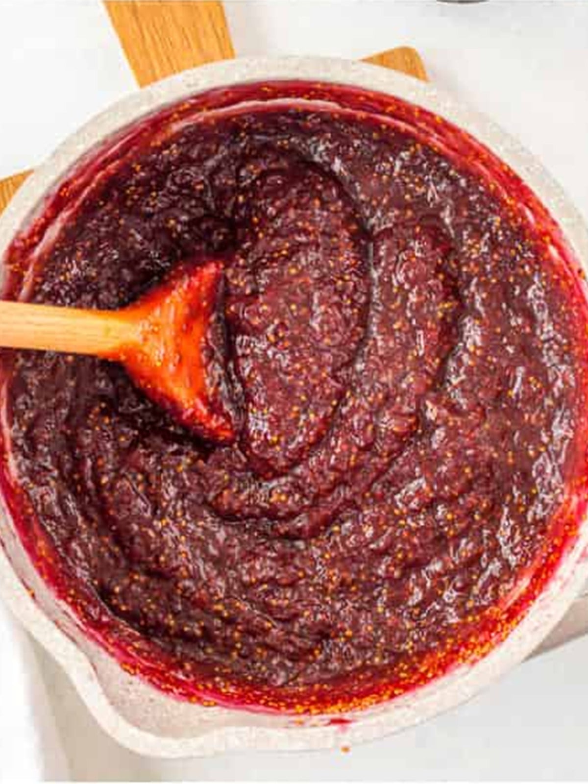 Thick simmered fig jam in a white dish.
