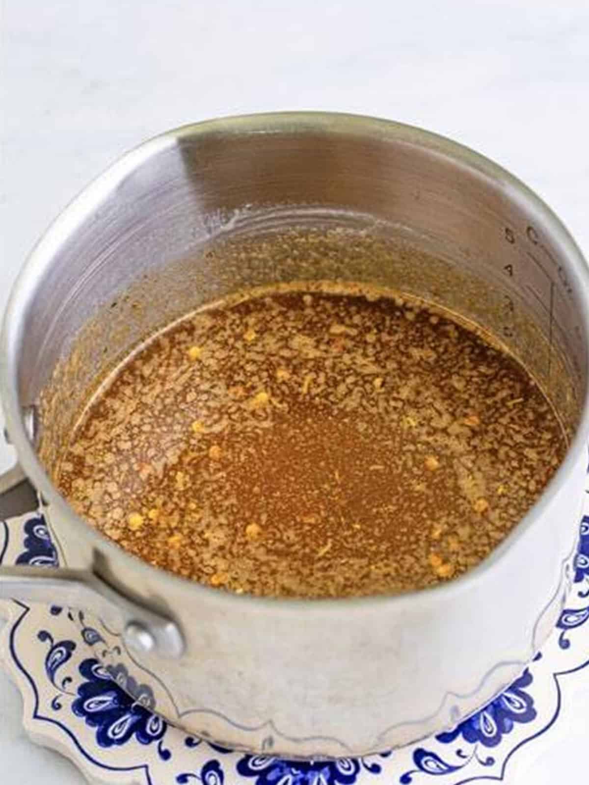 The spicy firecracker butter sauce stirred together in a saucepan.