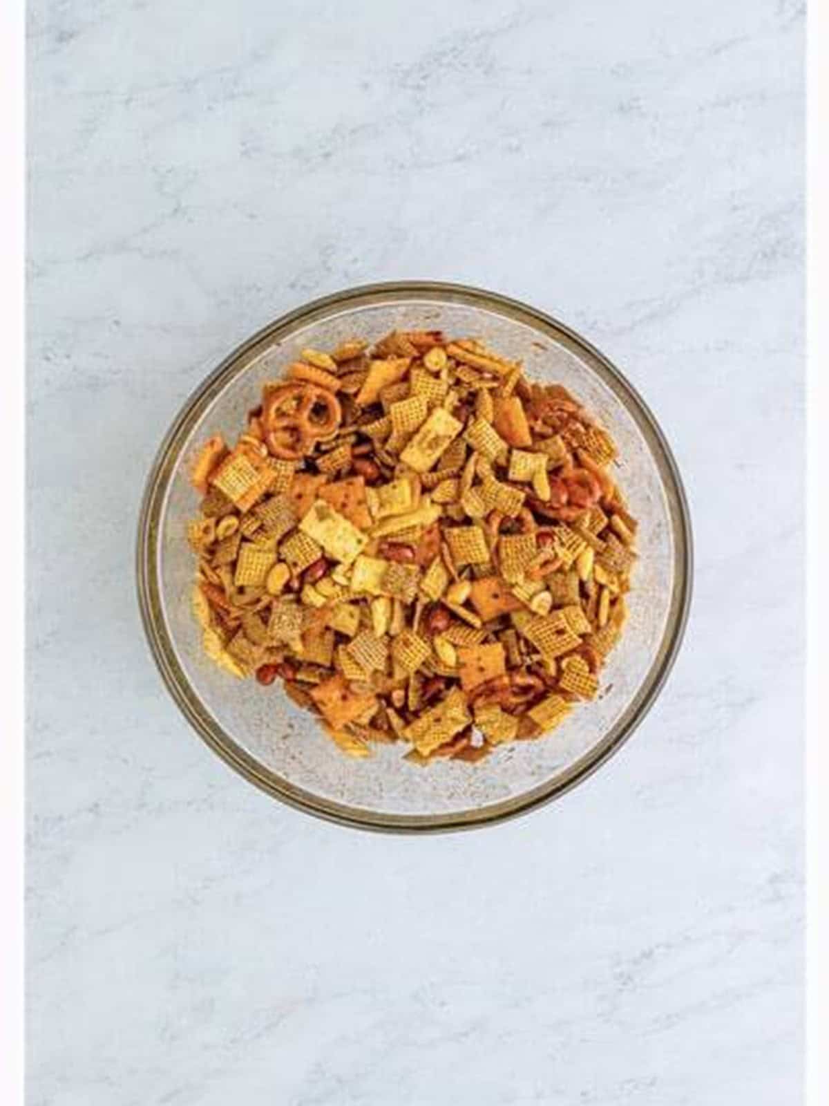 The snack mix tossed with the spicy firecracker sauce until coated.