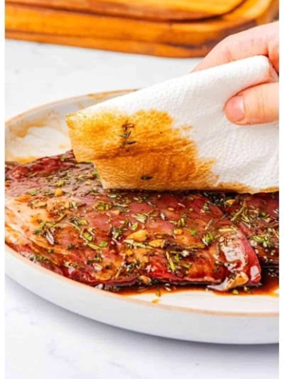 Sliced grilled flank steak resting on a plate.