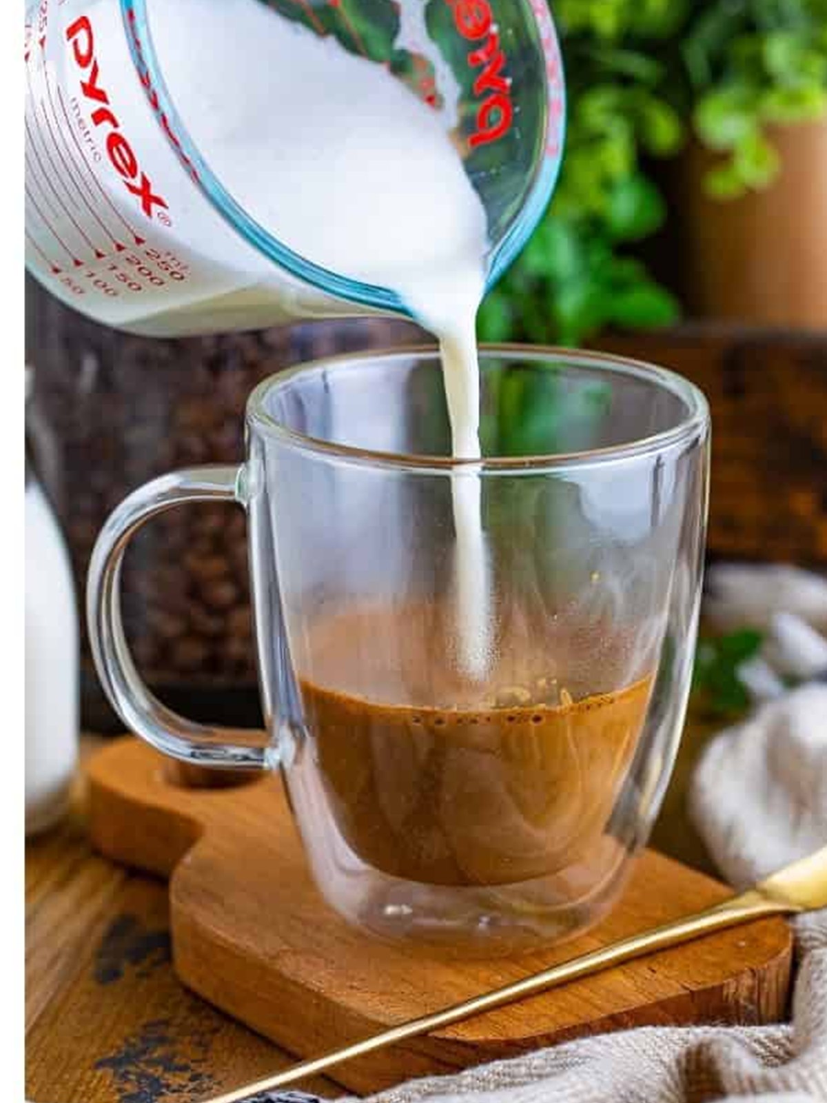 Pouring frothed milk into espresso to make a flat white