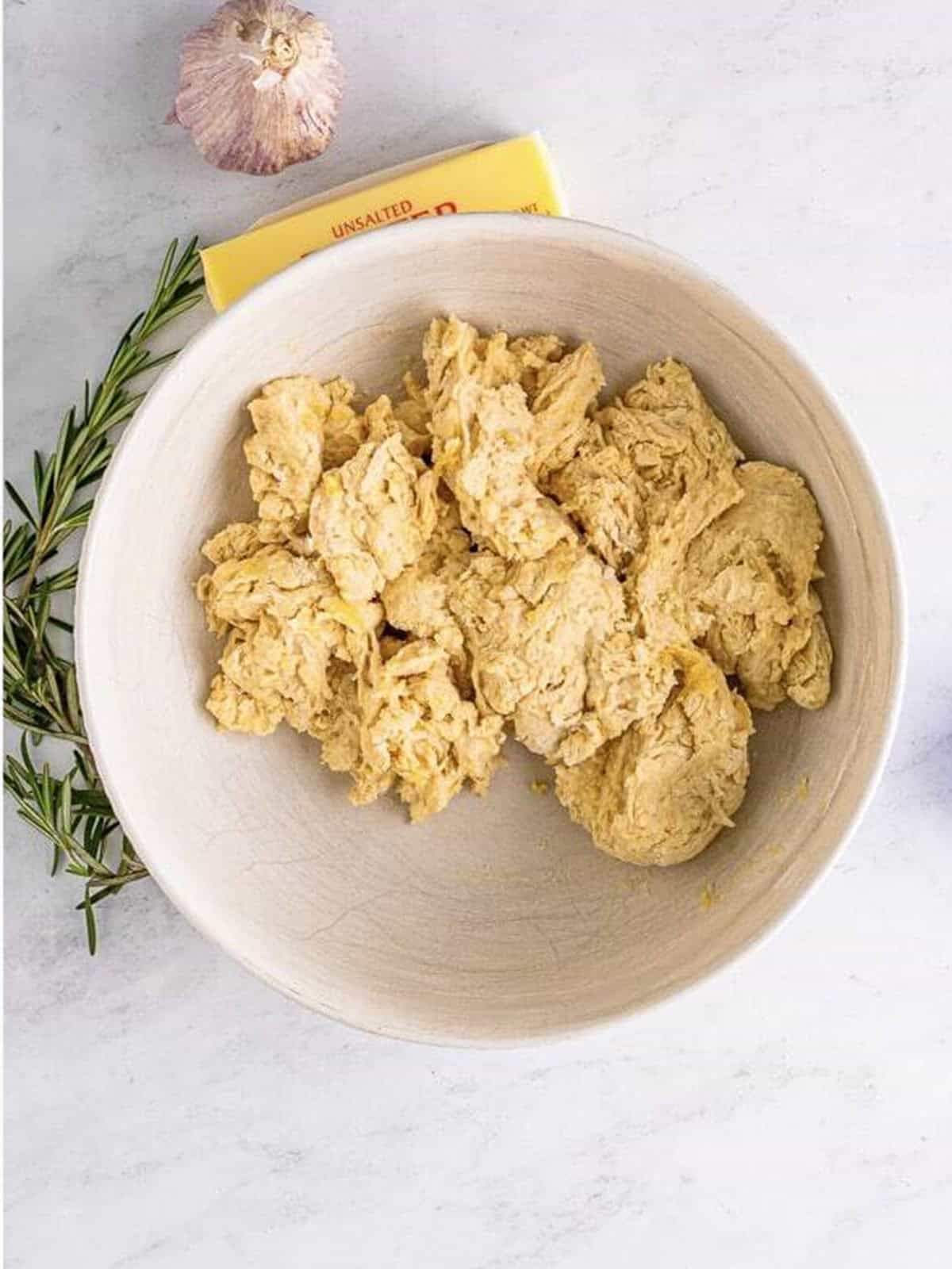Shaggy focaccia bread dough after stirring in olive oil, Parmesan, salt, and flour.