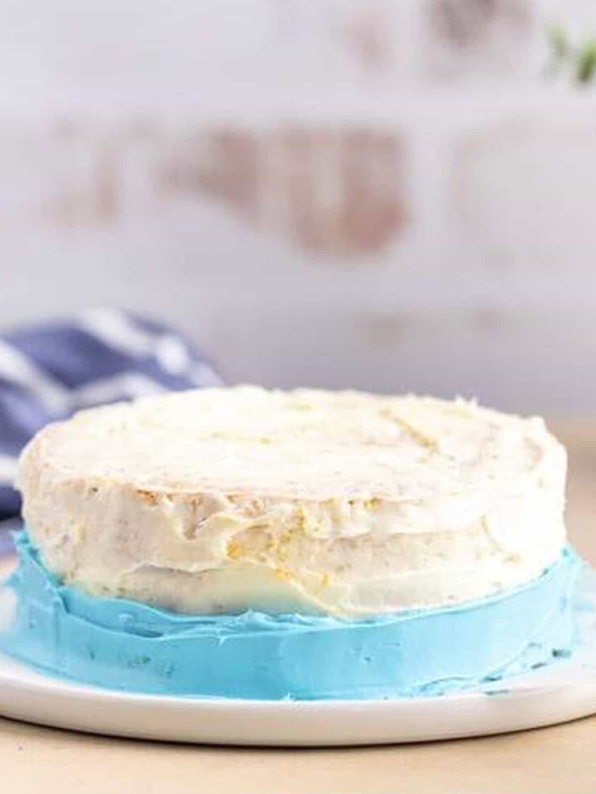 Frosting the smash cake in ombre bands from blue to white.
