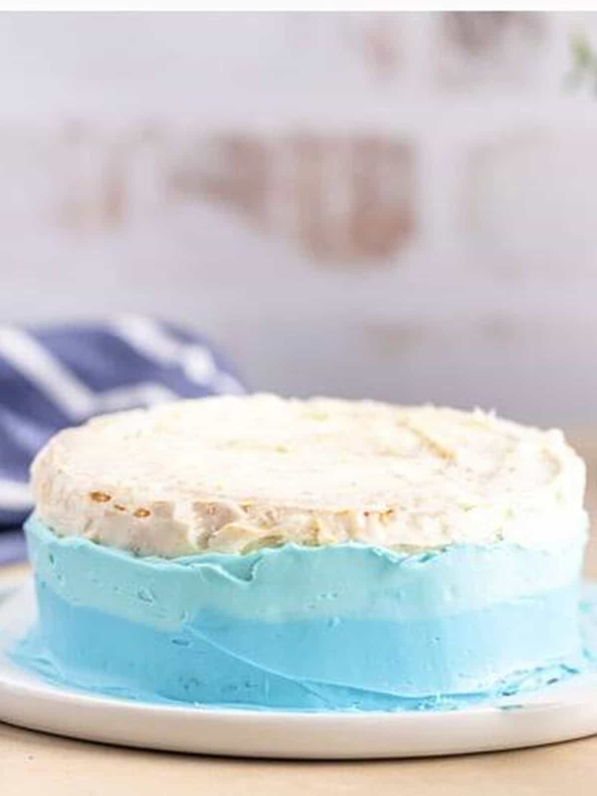 Smoothing the blue frosting around the bottom of the cake.