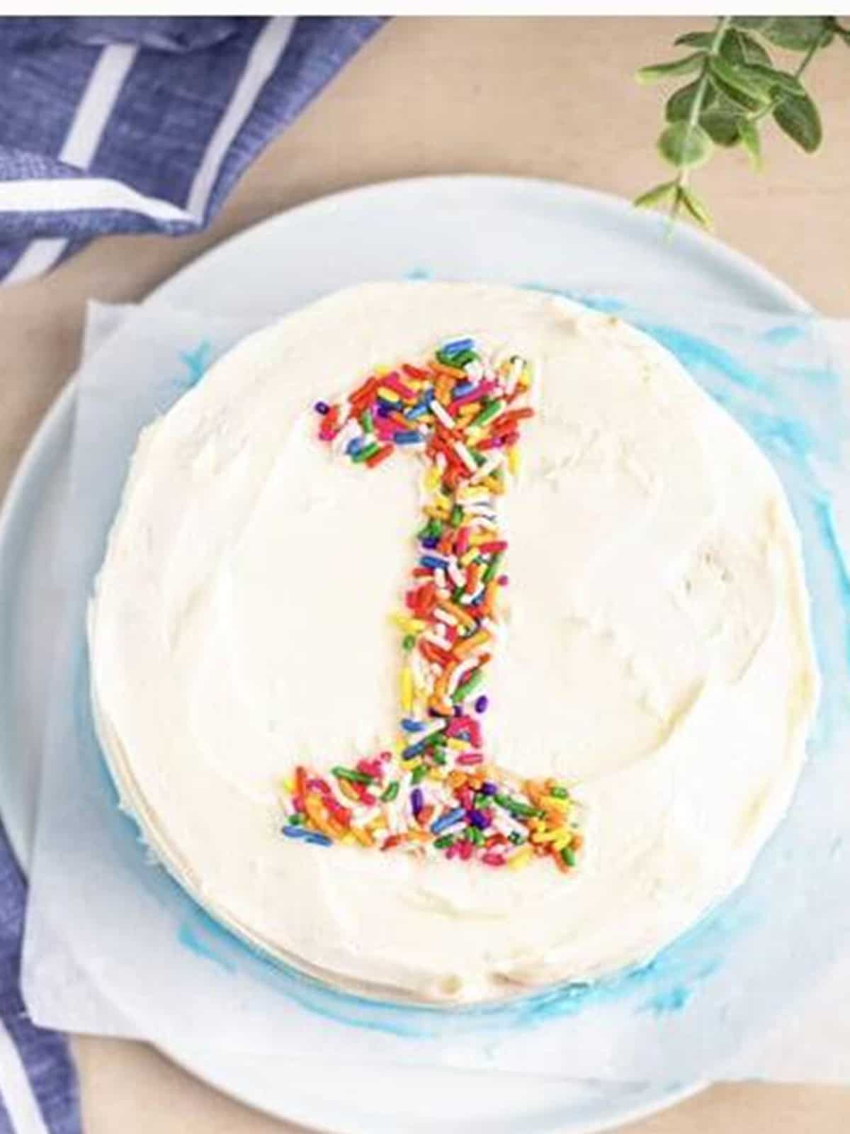 Finished ombre smash cake decorated with a sprinkle number one on top.