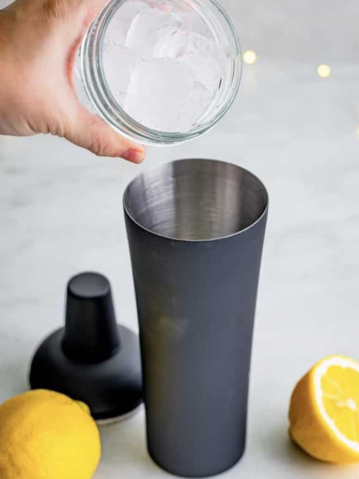Filling a cocktail shaker with ice to make a French 75.