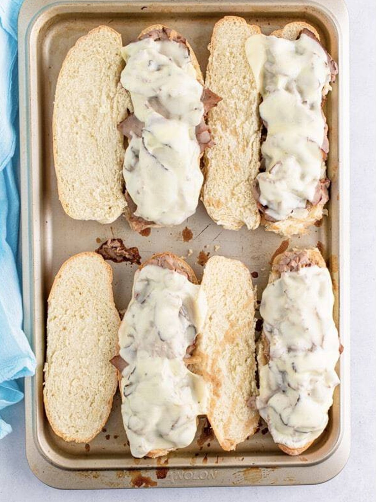 French dip sandwiches baked until the provolone cheese is melted and bubbly.