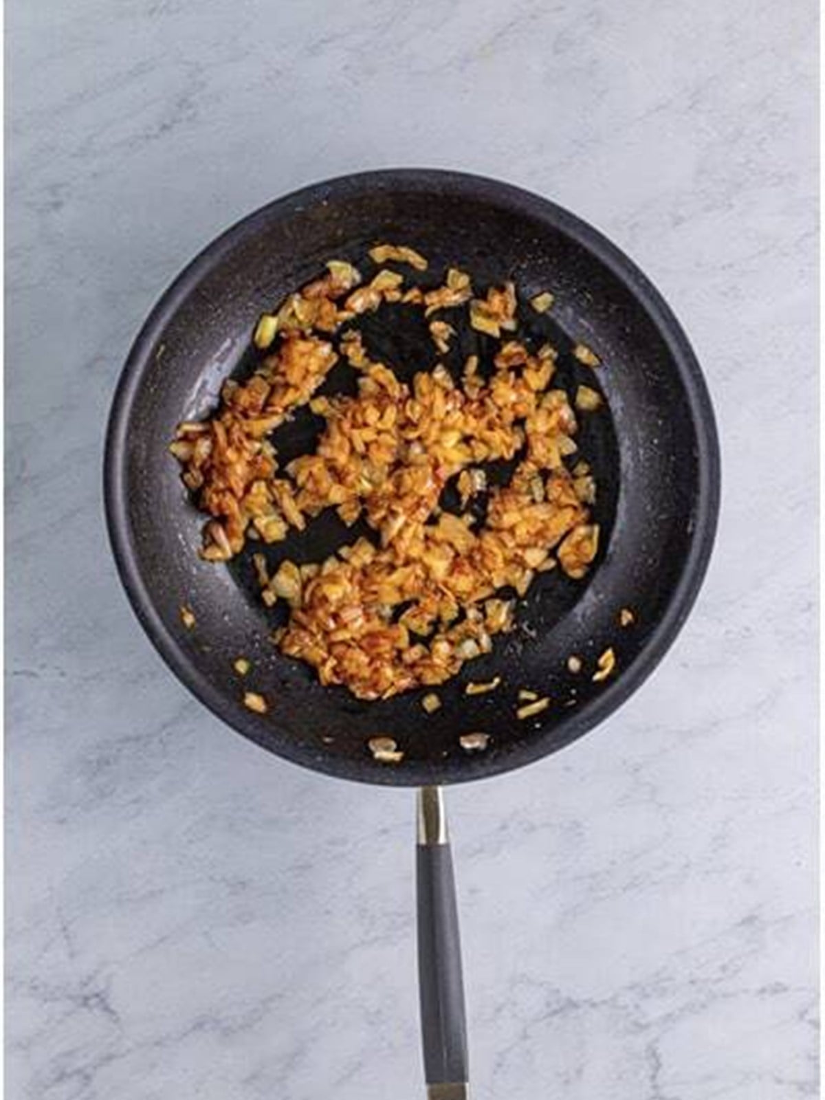 Onions caramelized to a deep golden brown in a skillet.