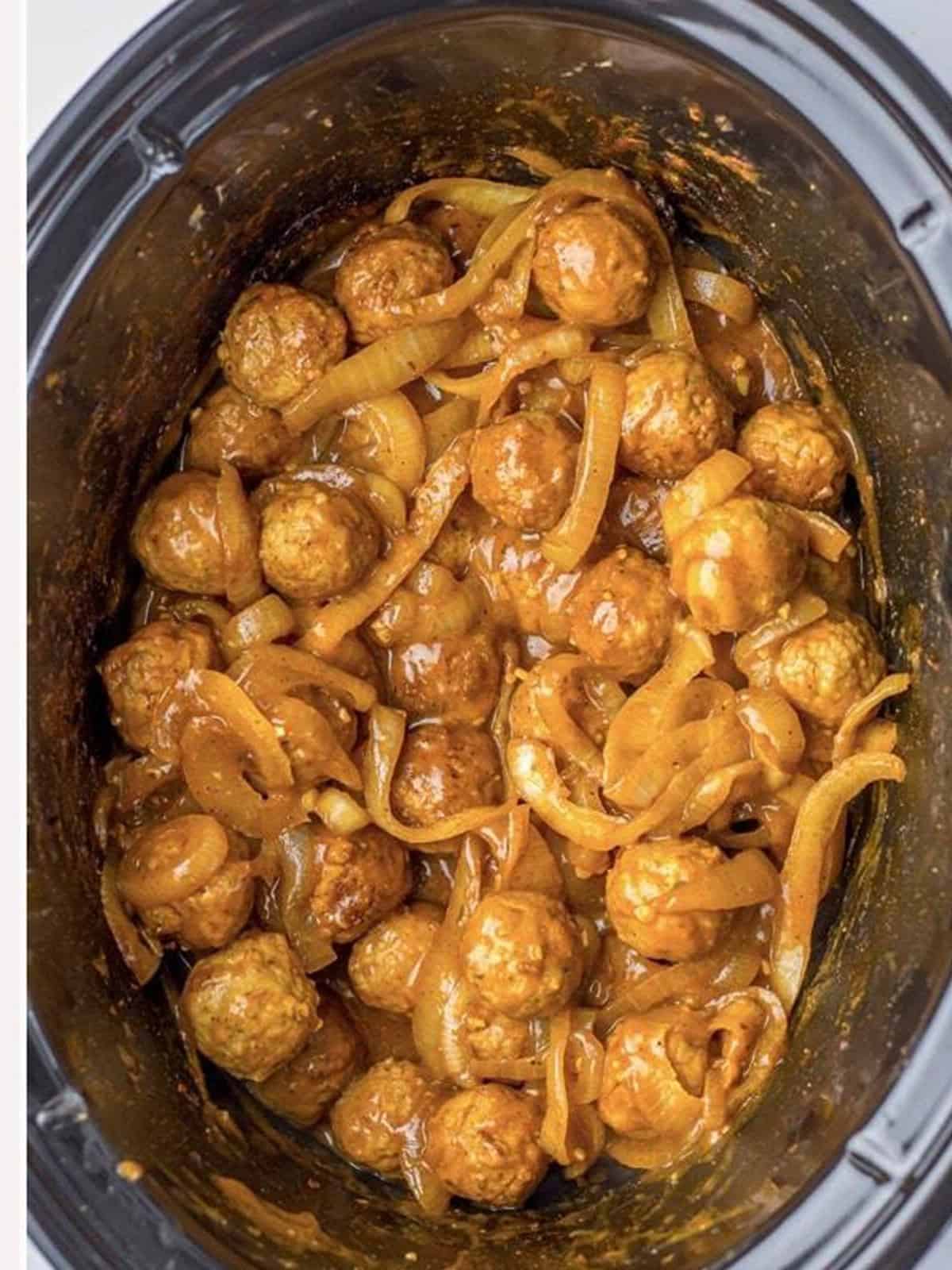 Finished slow cooker French onion meatballs coated in rich brown gravy.