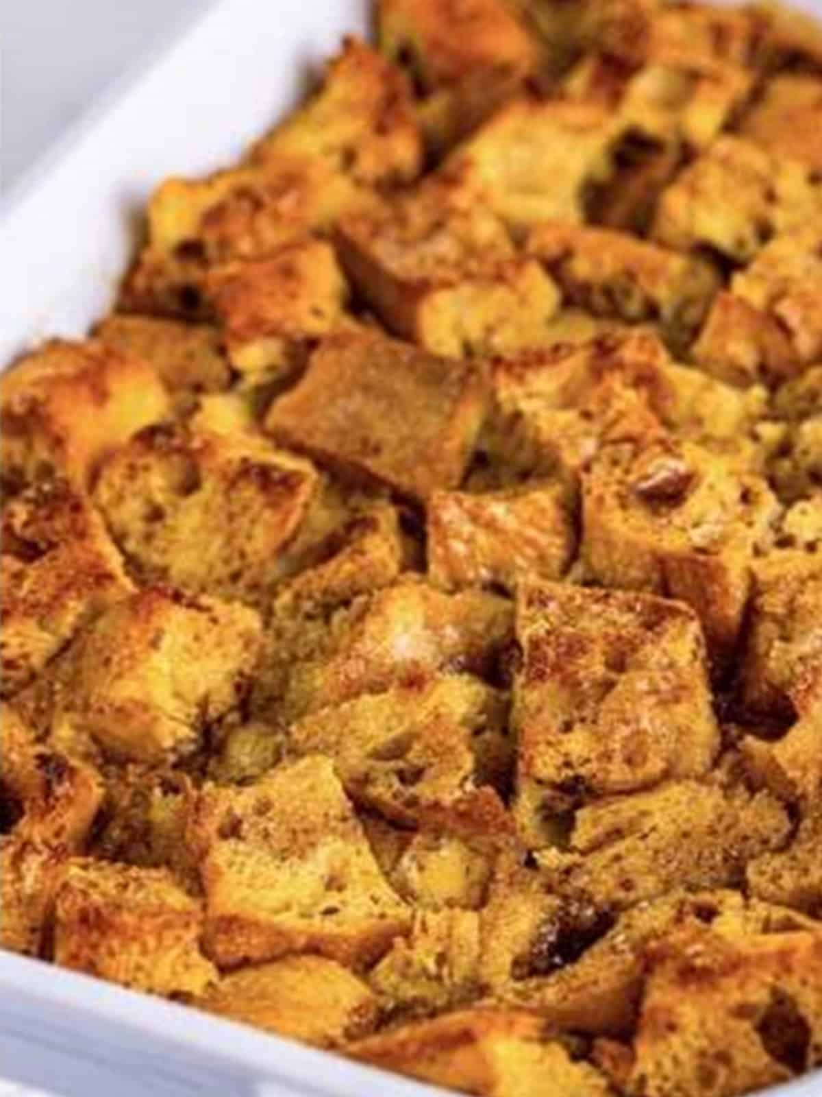 Golden baked french toast casserole in a white dish.