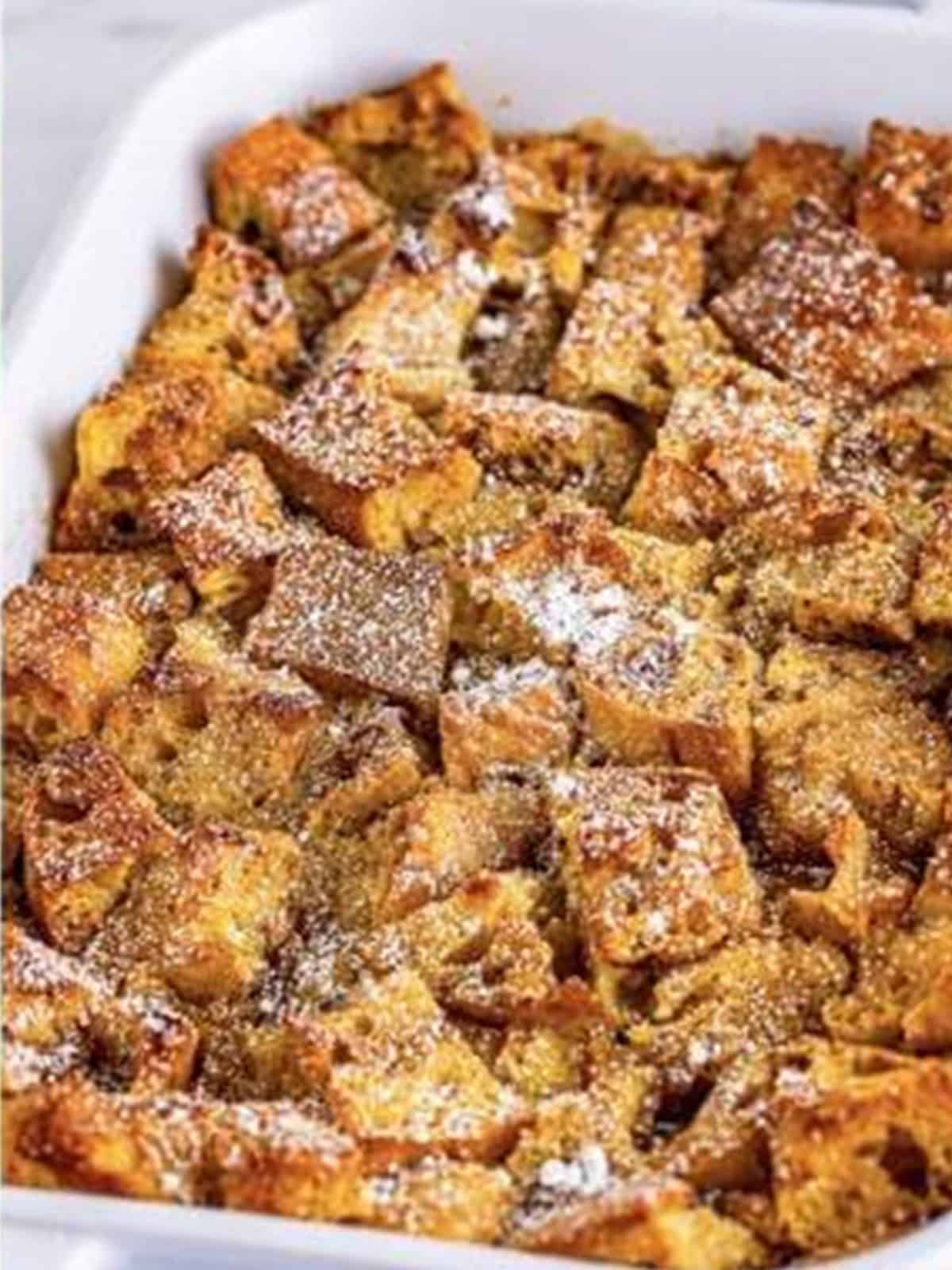 Baked french toast casserole dusted with powdered sugar.
