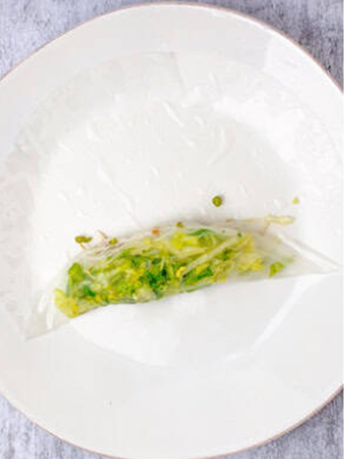 Bottom of the rice paper wrapper folded over the filling.