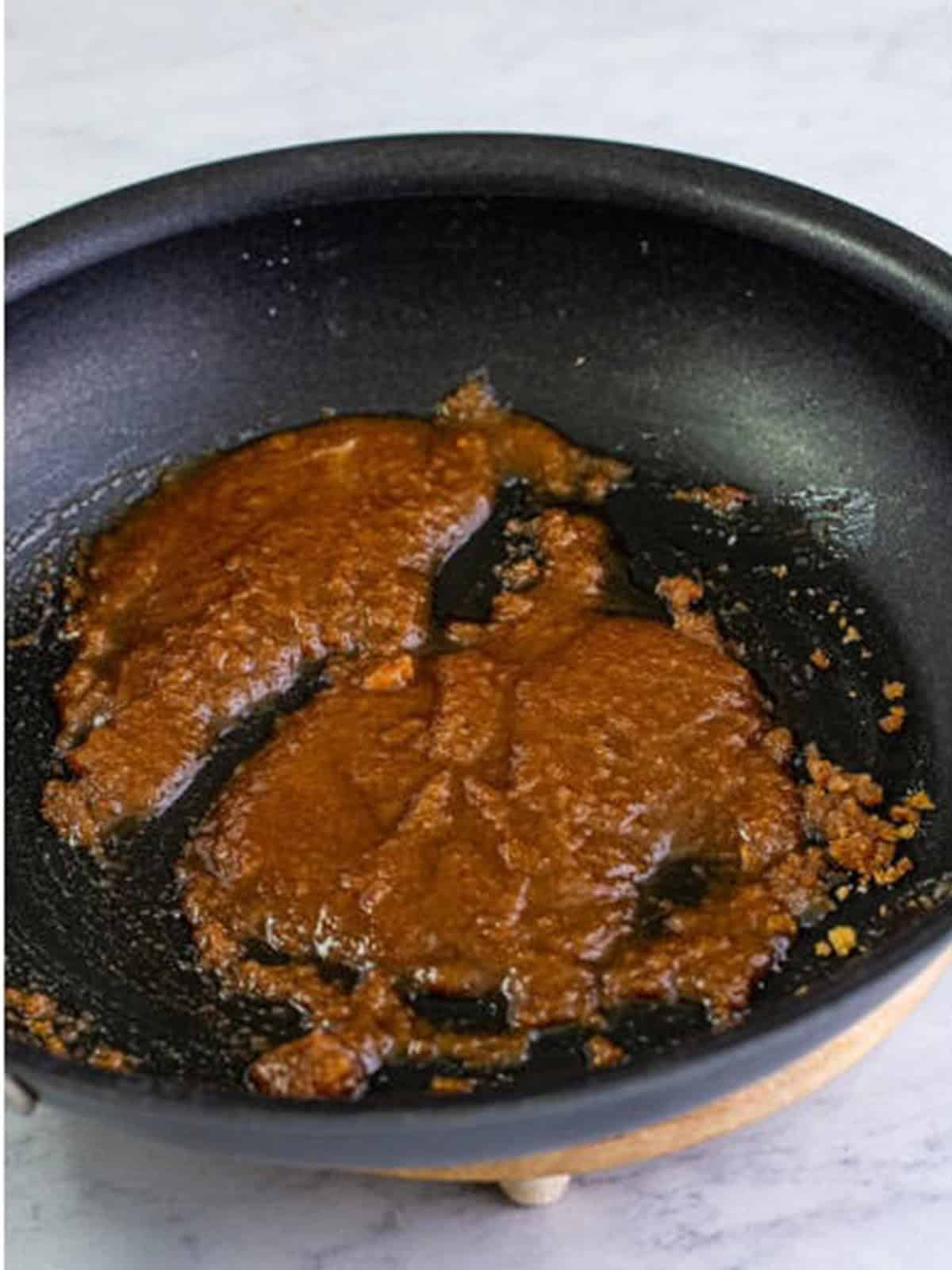 Butter, granulated sugar, brown sugar, and cinnamon melted together in a skillet.