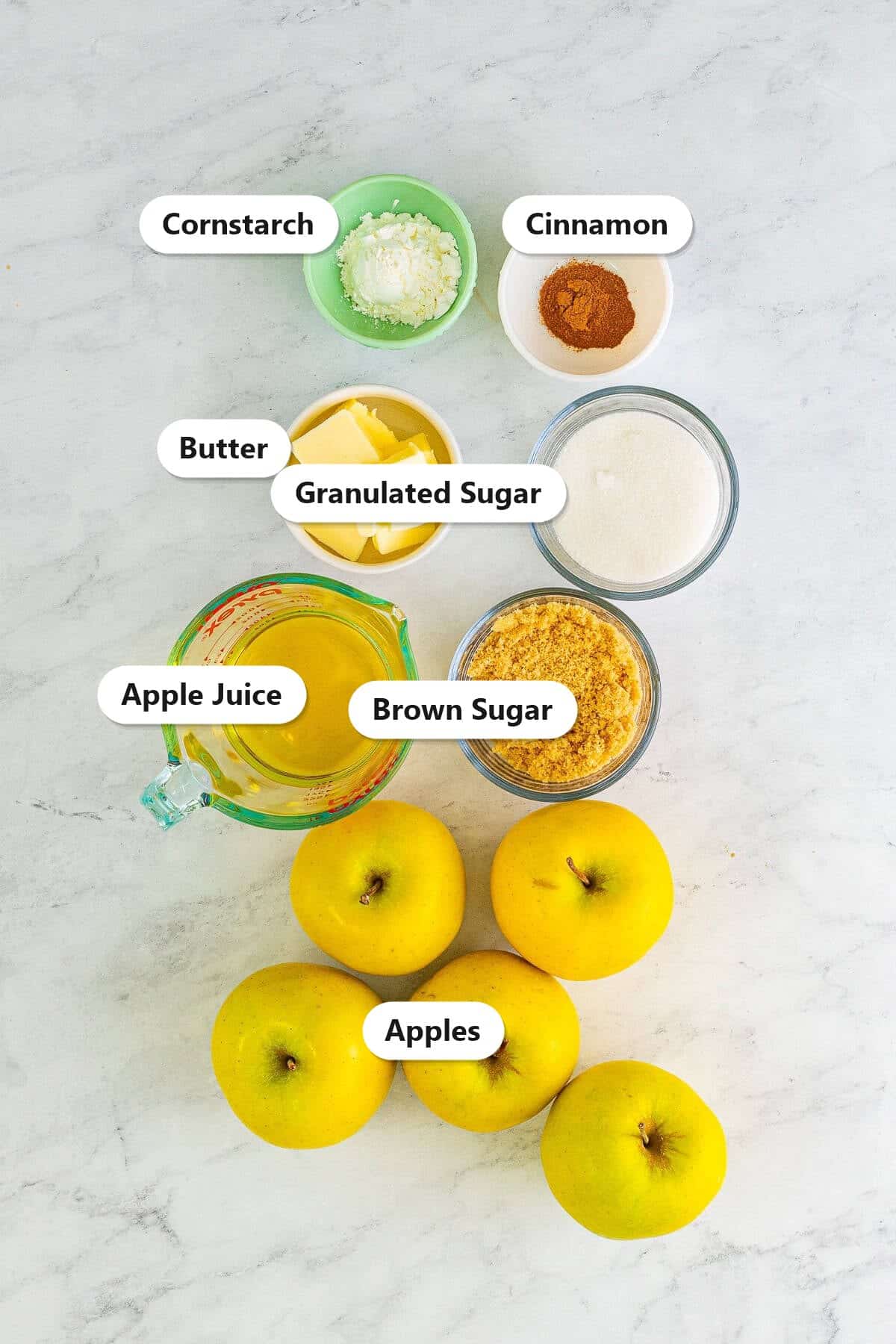 Labeled ingredients for fried apples including Golden Delicious apples, butter, granulated sugar, brown sugar, cinnamon, apple juice, and cornstarch.