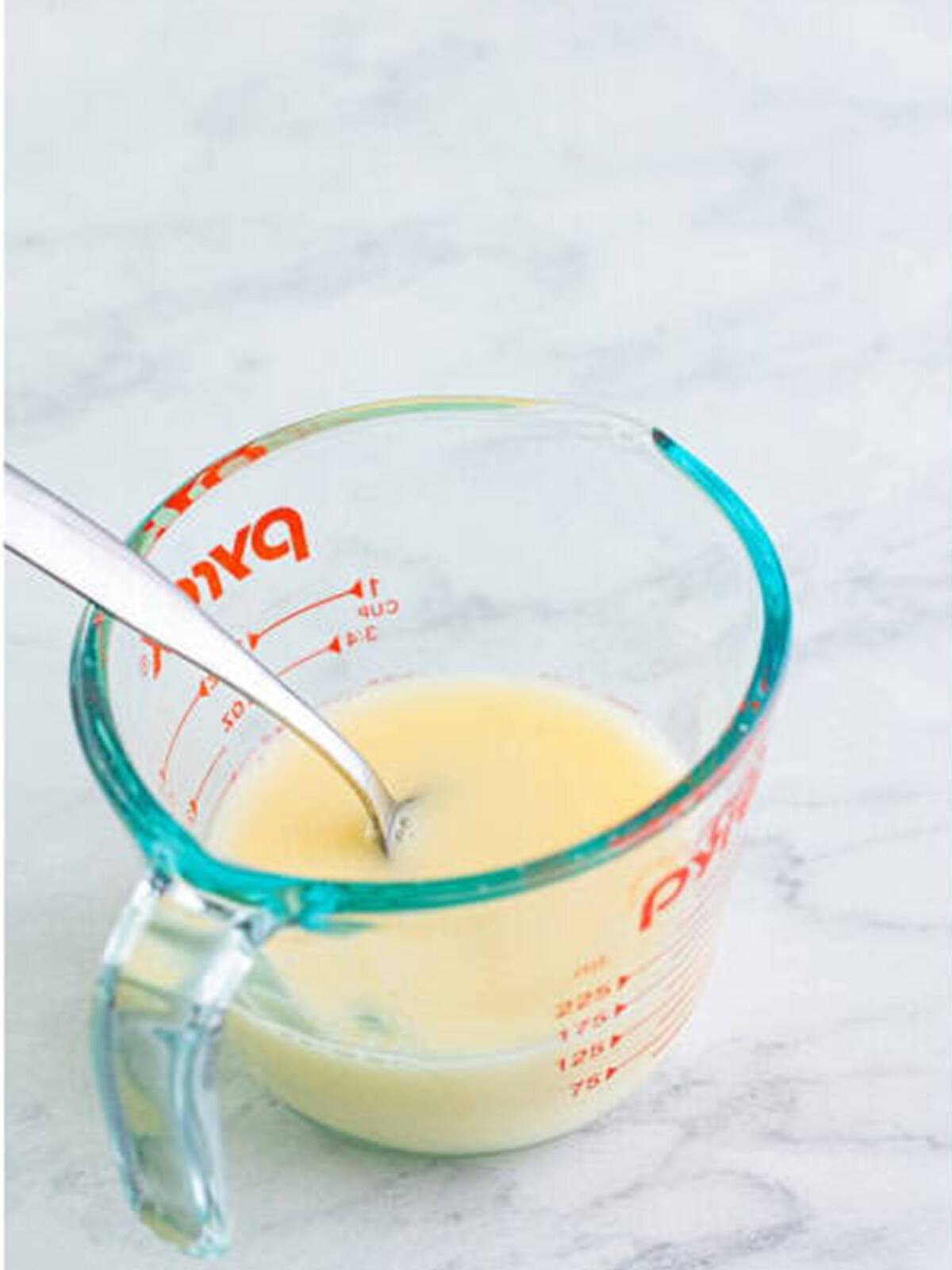 Apple juice and cornstarch whisked together in a measuring cup to make a slurry.
