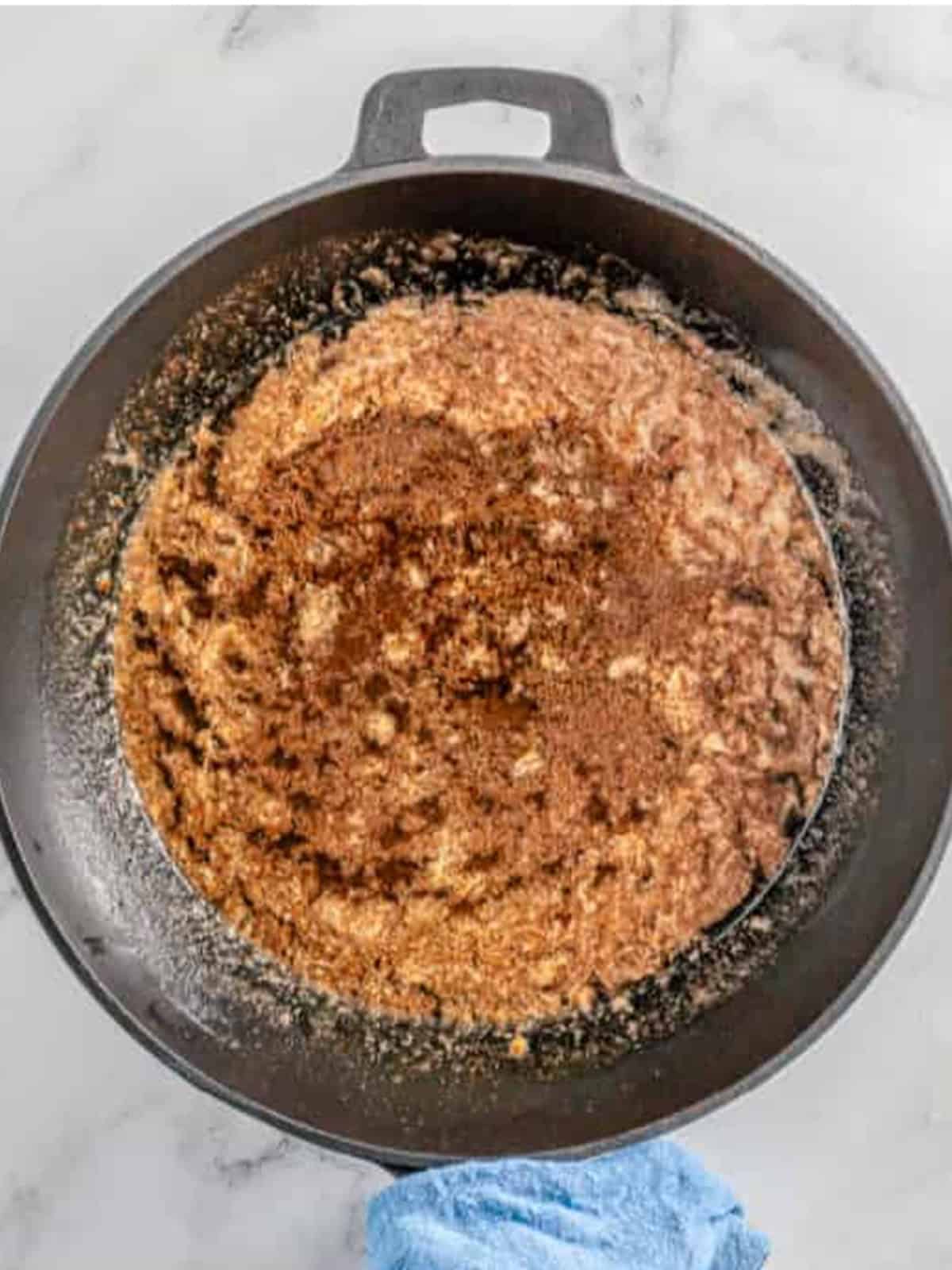 Melted butter, brown sugar, and cinnamon stirred together in a skillet.