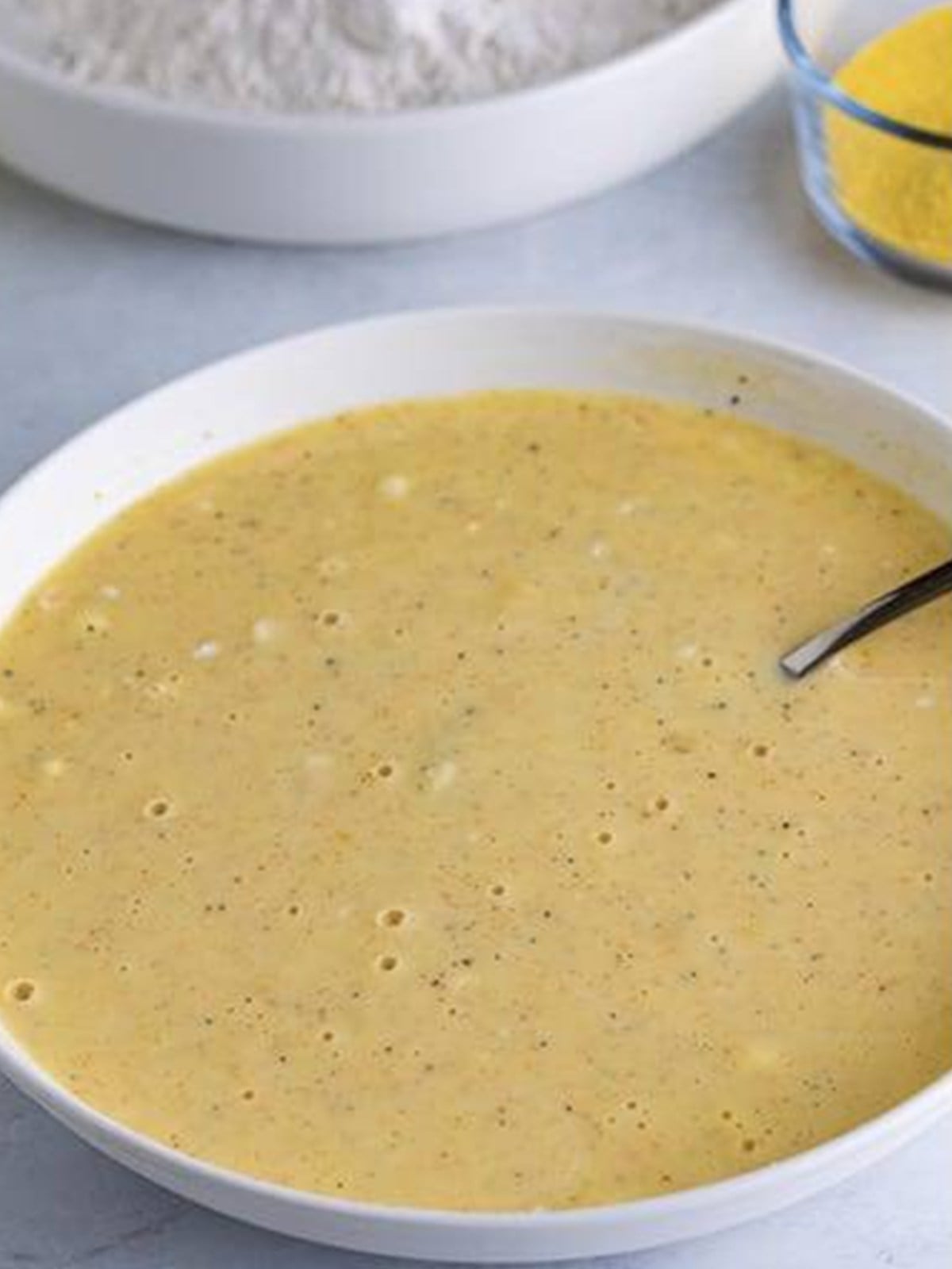 Buttermilk and egg batter whisked together in a white bowl.