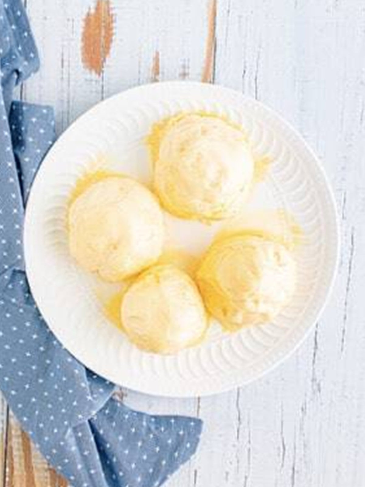 Scoops of vanilla ice cream formed into balls on a plate for fried ice cream.