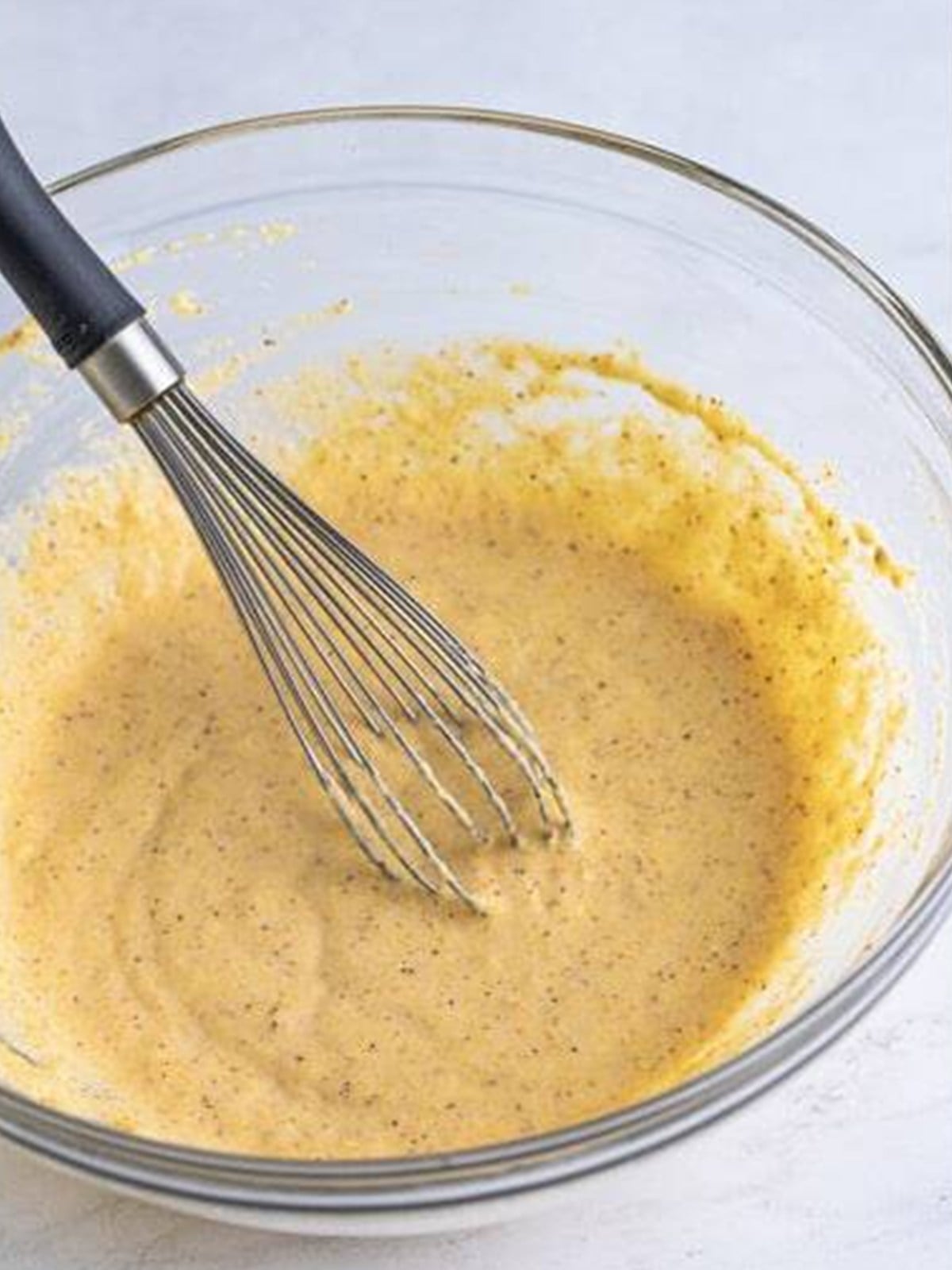 Smooth whisked batter in a glass bowl.