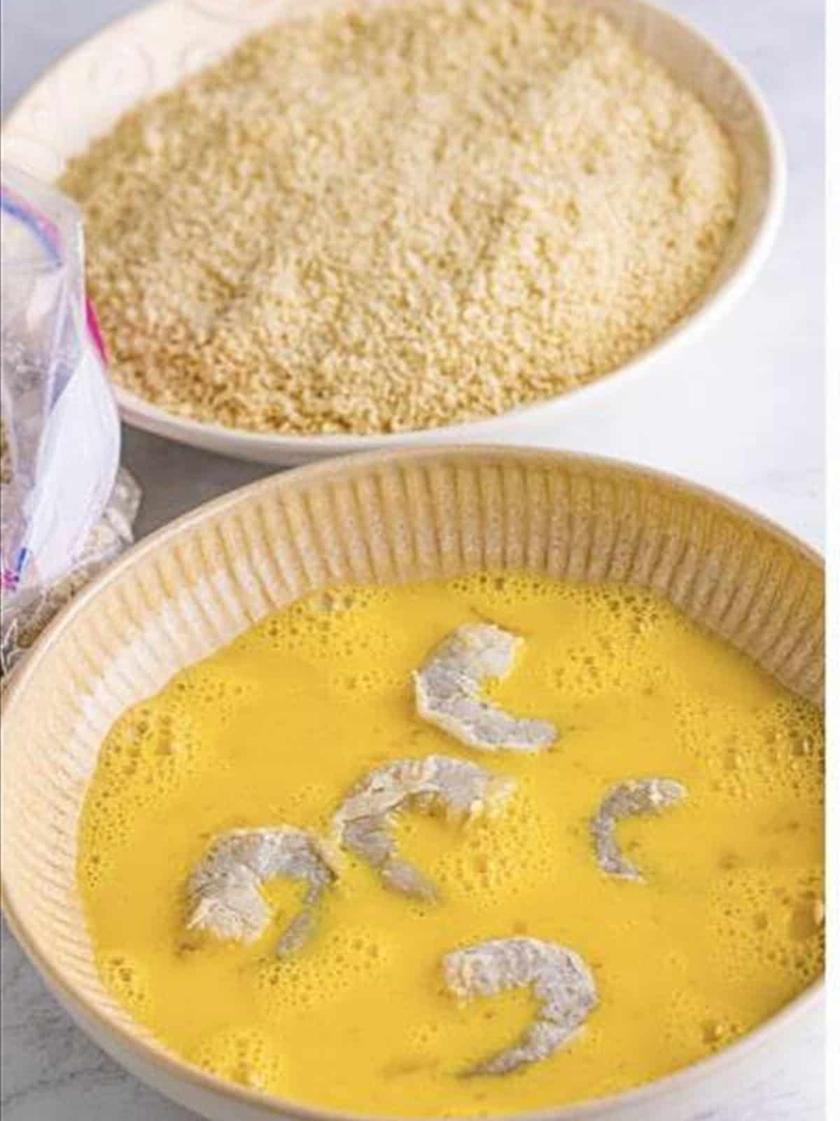 Dipping floured shrimp into beaten egg for fried shrimp recipe.