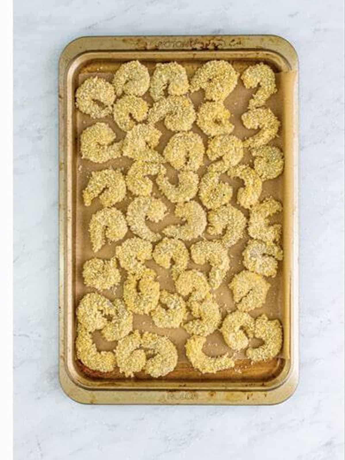Breaded shrimp arranged on a tray for fried shrimp recipe.