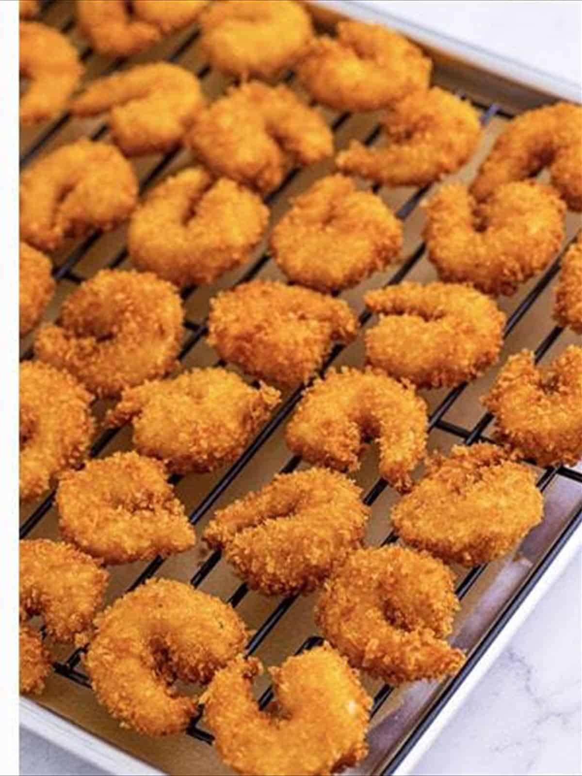 Crispy fried shrimp on a wire rack.