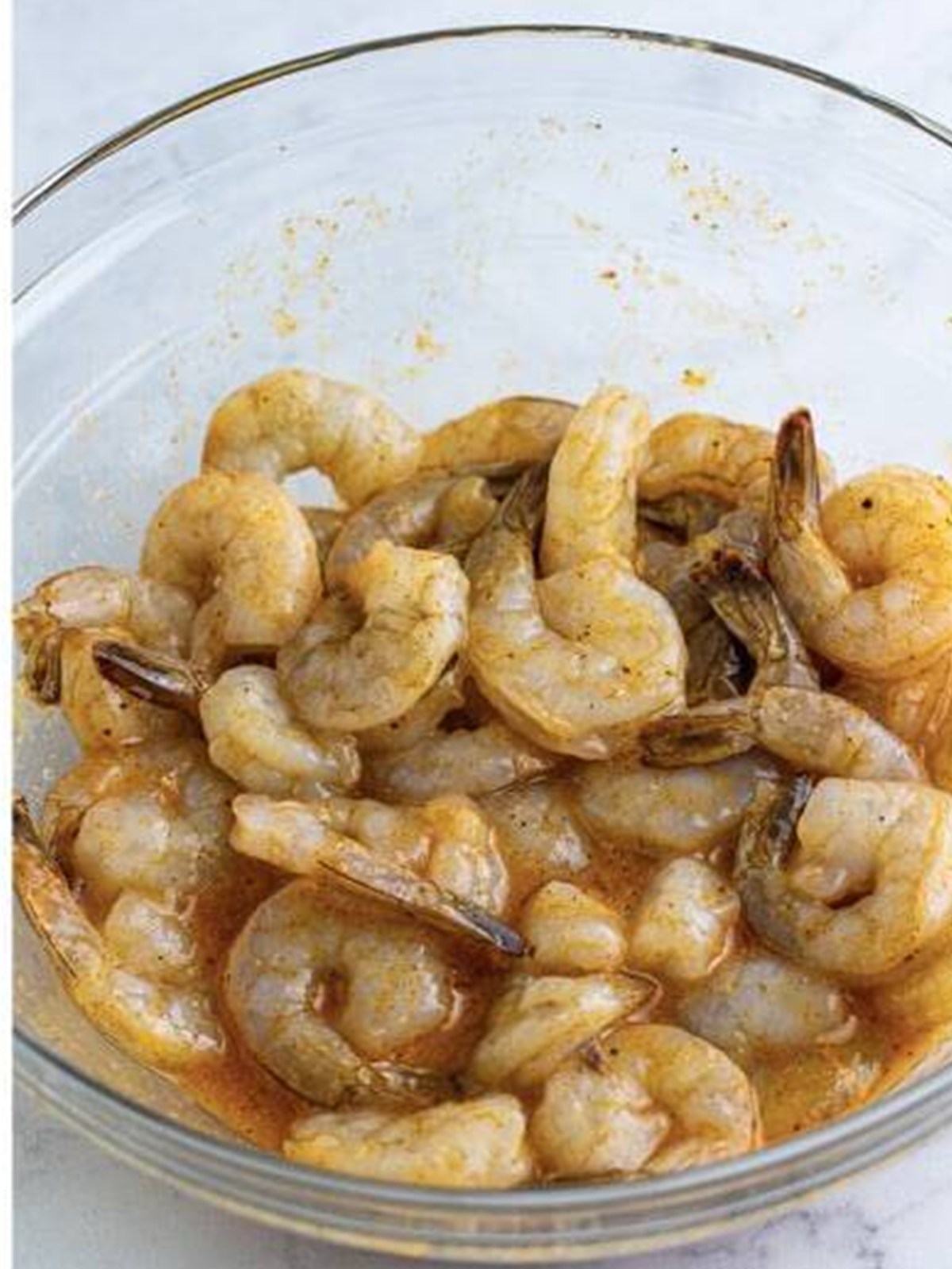 Coating raw shrimp in the seasoned egg mixture for Fried Shrimp.