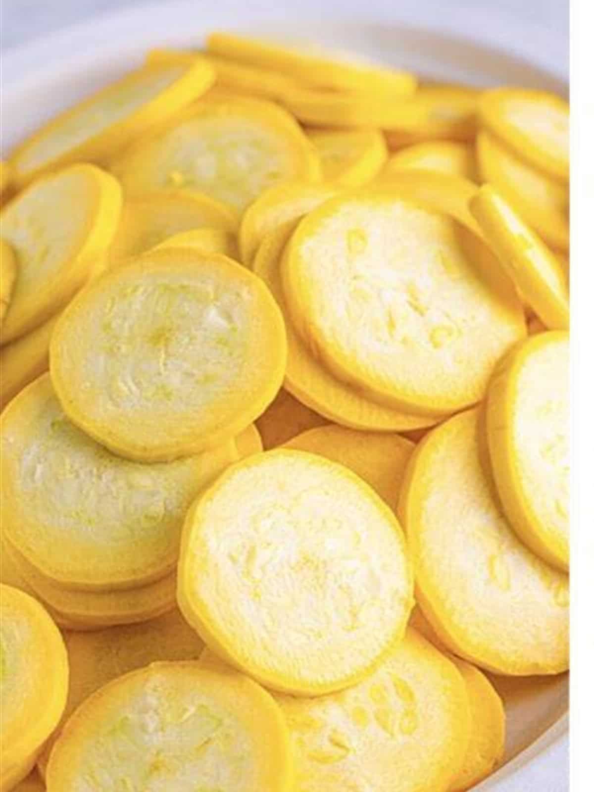 Yellow squash sliced into thin rounds for frying.