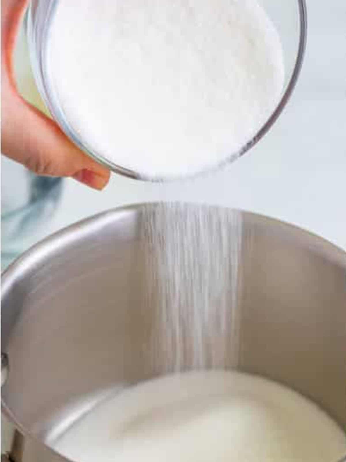 Sugar poured into a saucepan to make lemonade syrup for frosted lemonade.