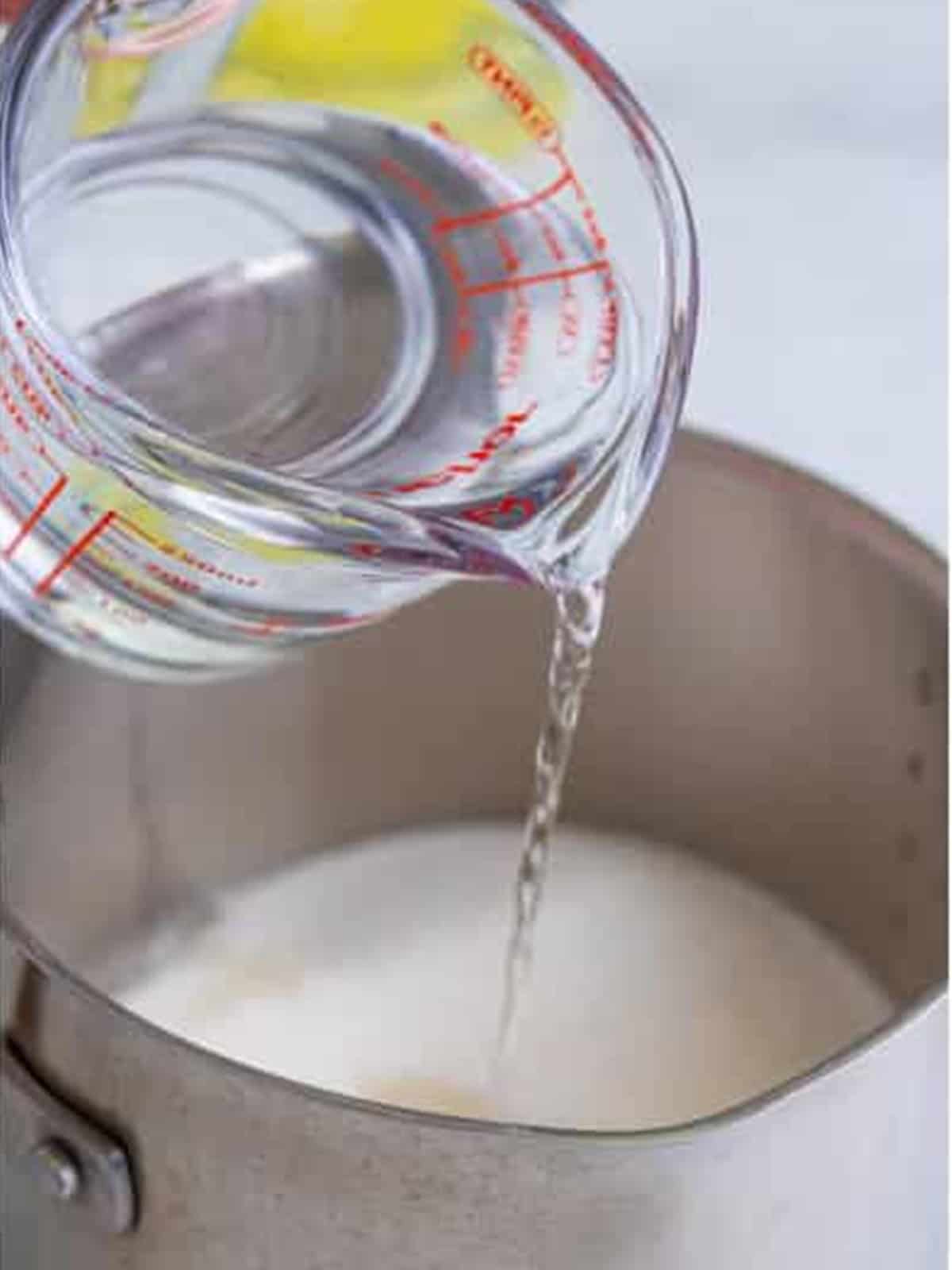 Water poured into the saucepan to make the lemonade base for frosted lemonade.