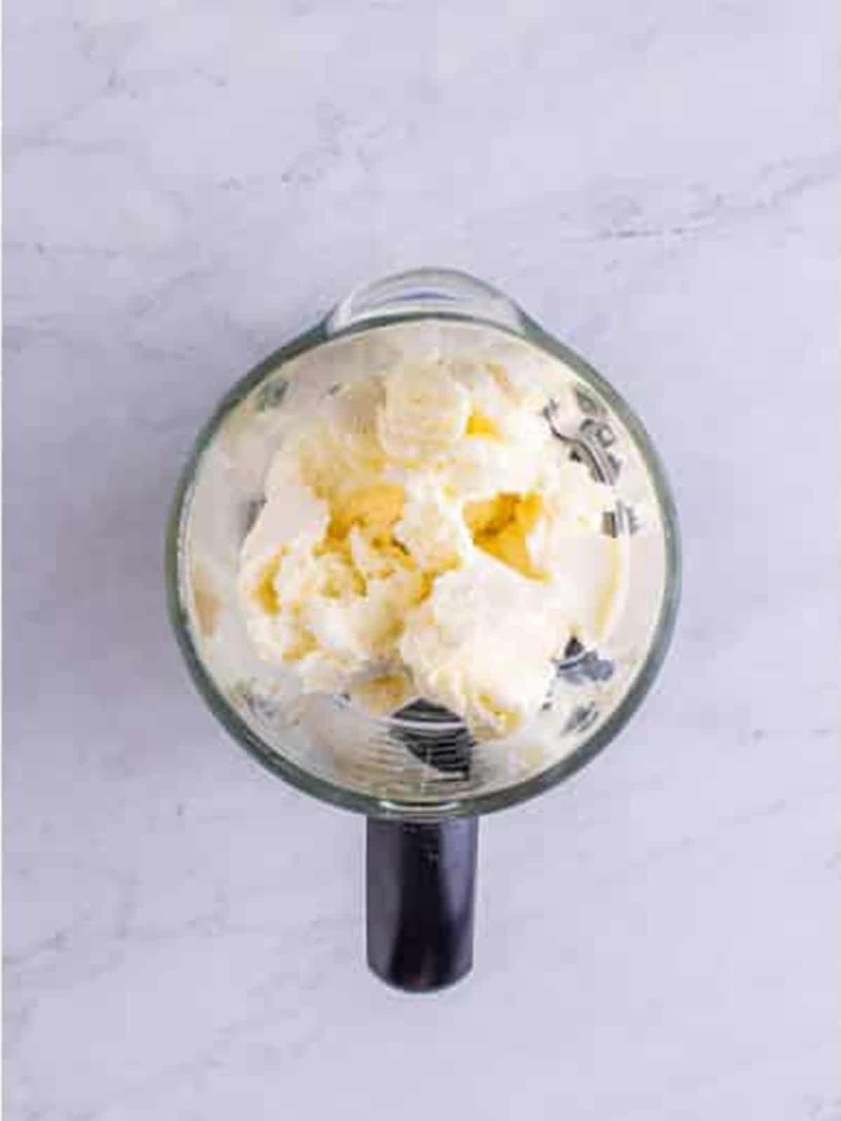 Vanilla ice cream scooped into a blender for frosted lemonade.