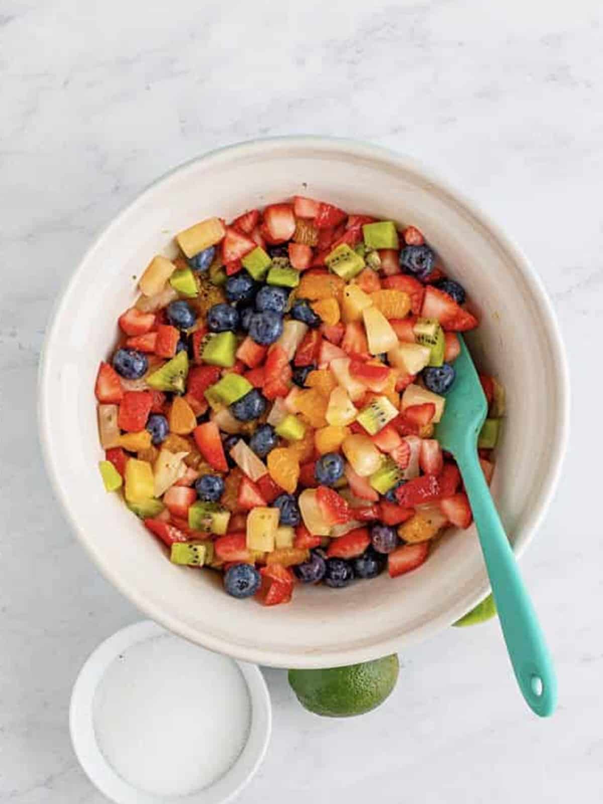 Fruit salsa tossed with a honey lime dressing in a bowl.