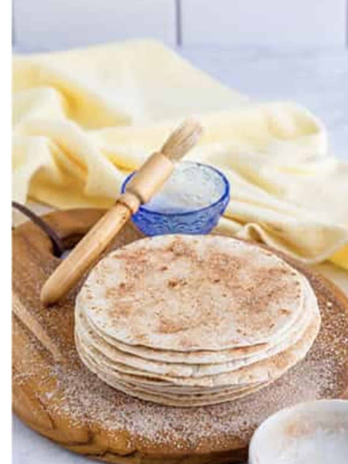 A stack of flour tortillas brushed with butter and sprinkled with cinnamon sugar for baked chips.