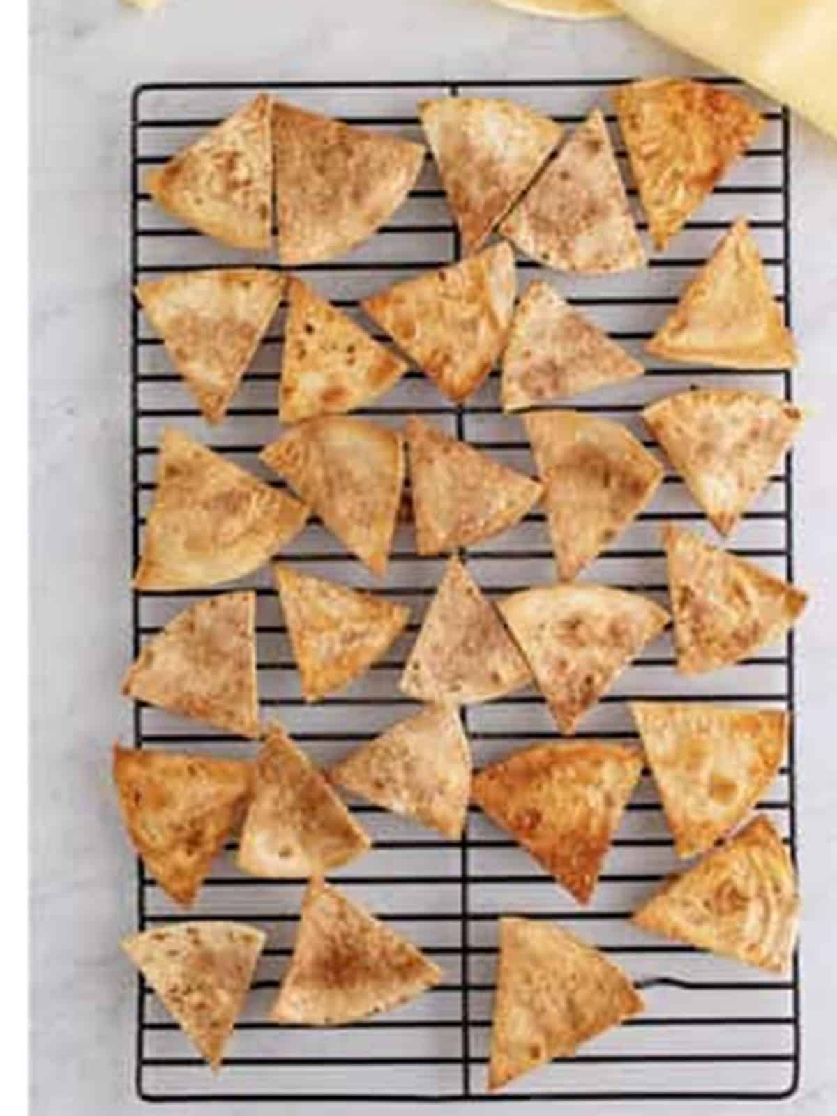 Crisp baked cinnamon tortilla chips cooling on a wire rack to serve with fruit salsa.