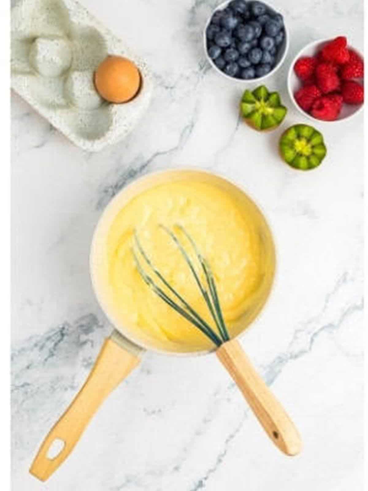 Cooking the pastry cream until thick in a saucepan for fruit tartlets.