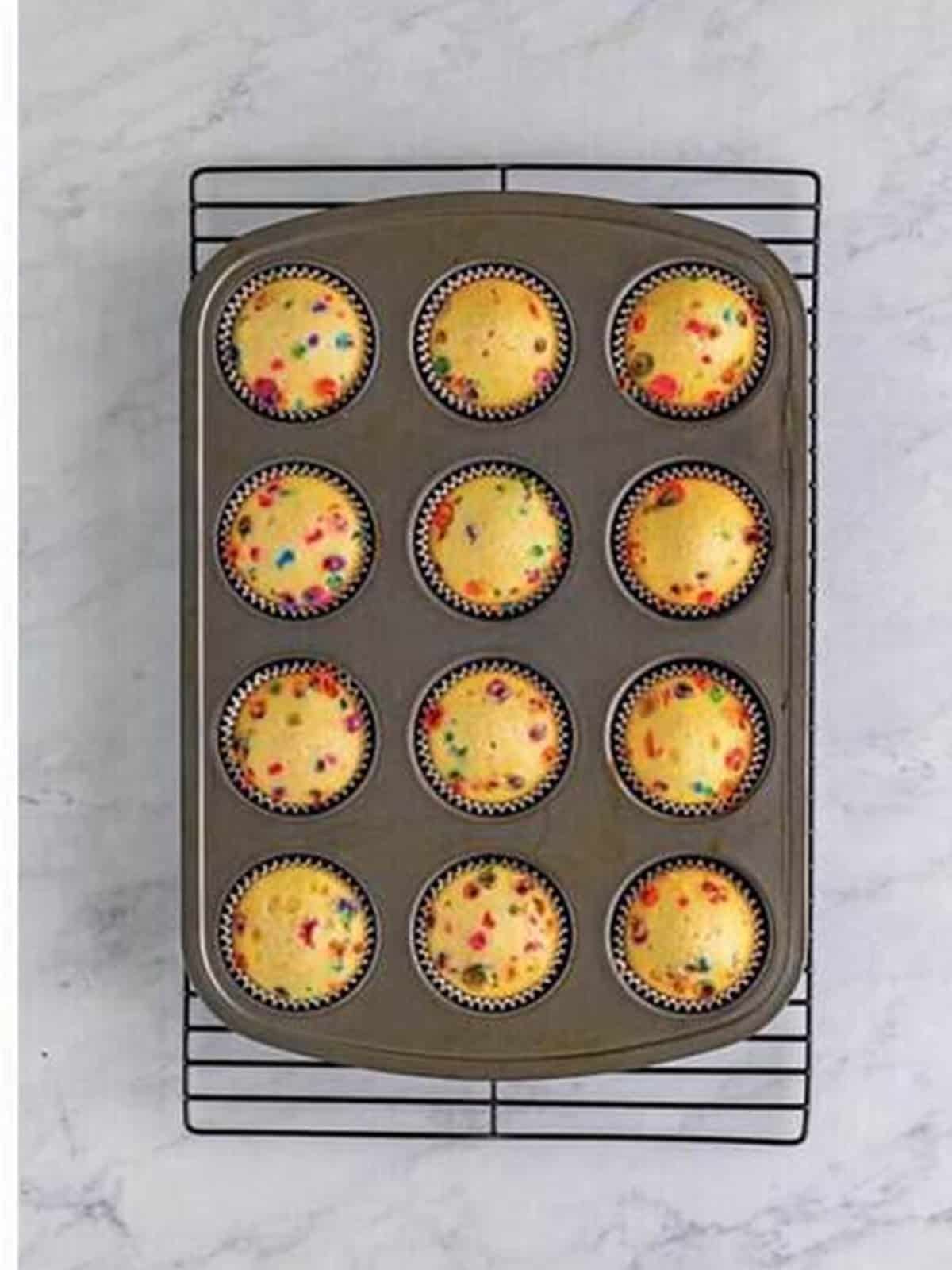 Baked Funfetti Cupcakes cooling on a wire rack.