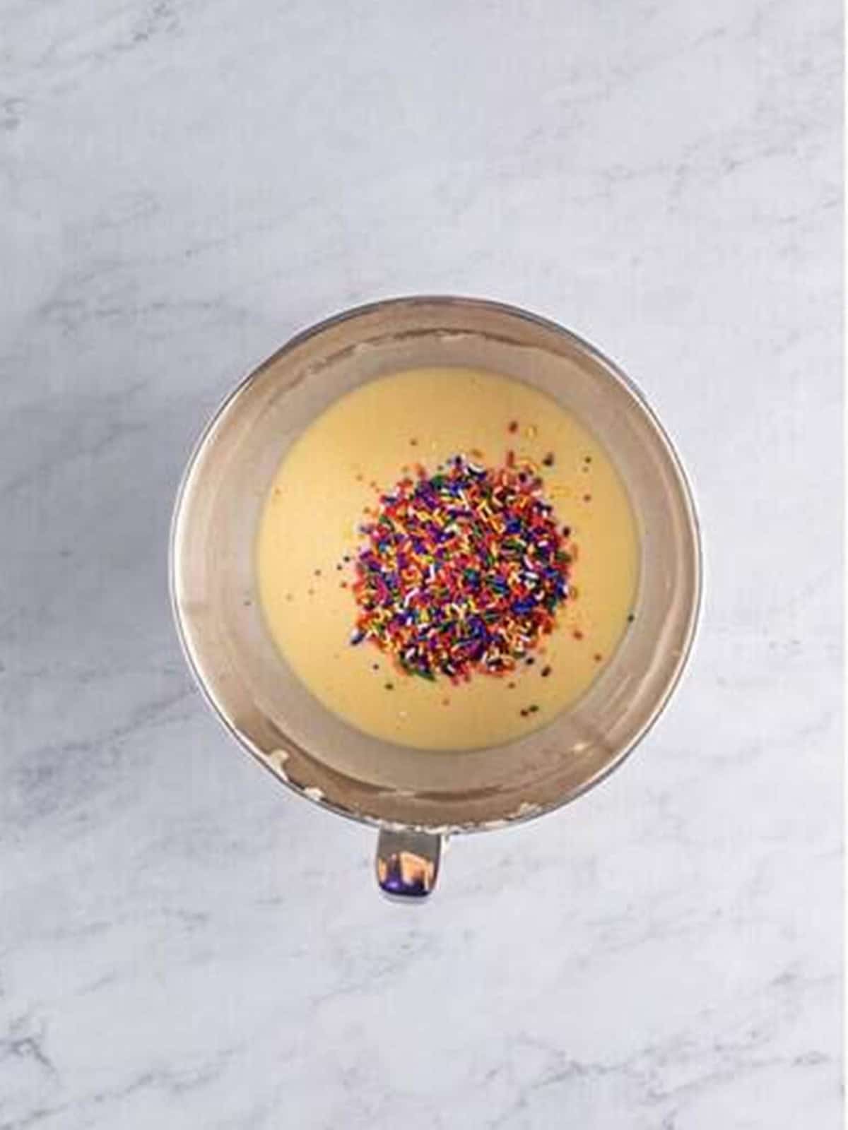 Stirring rainbow sprinkles into the Funfetti Cupcakes batter.