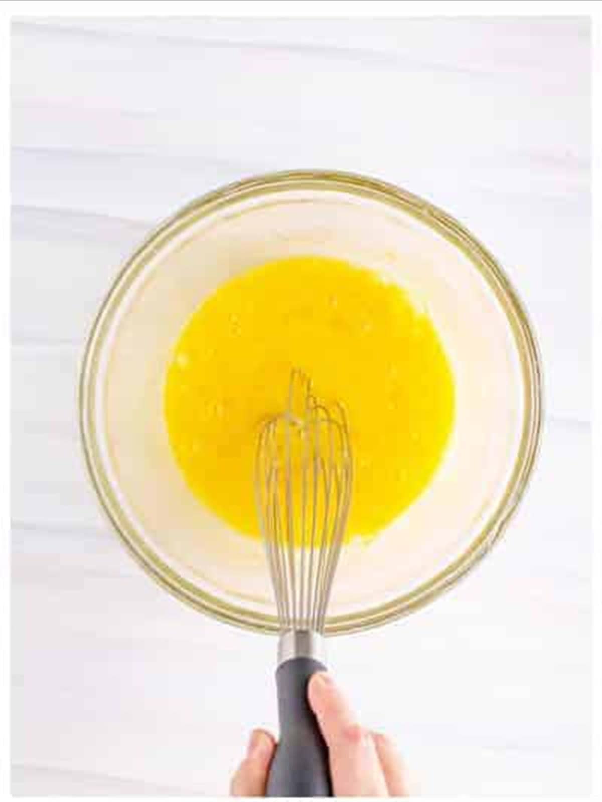 Whisking eggs and sugar smooth for funnel cake recipe.