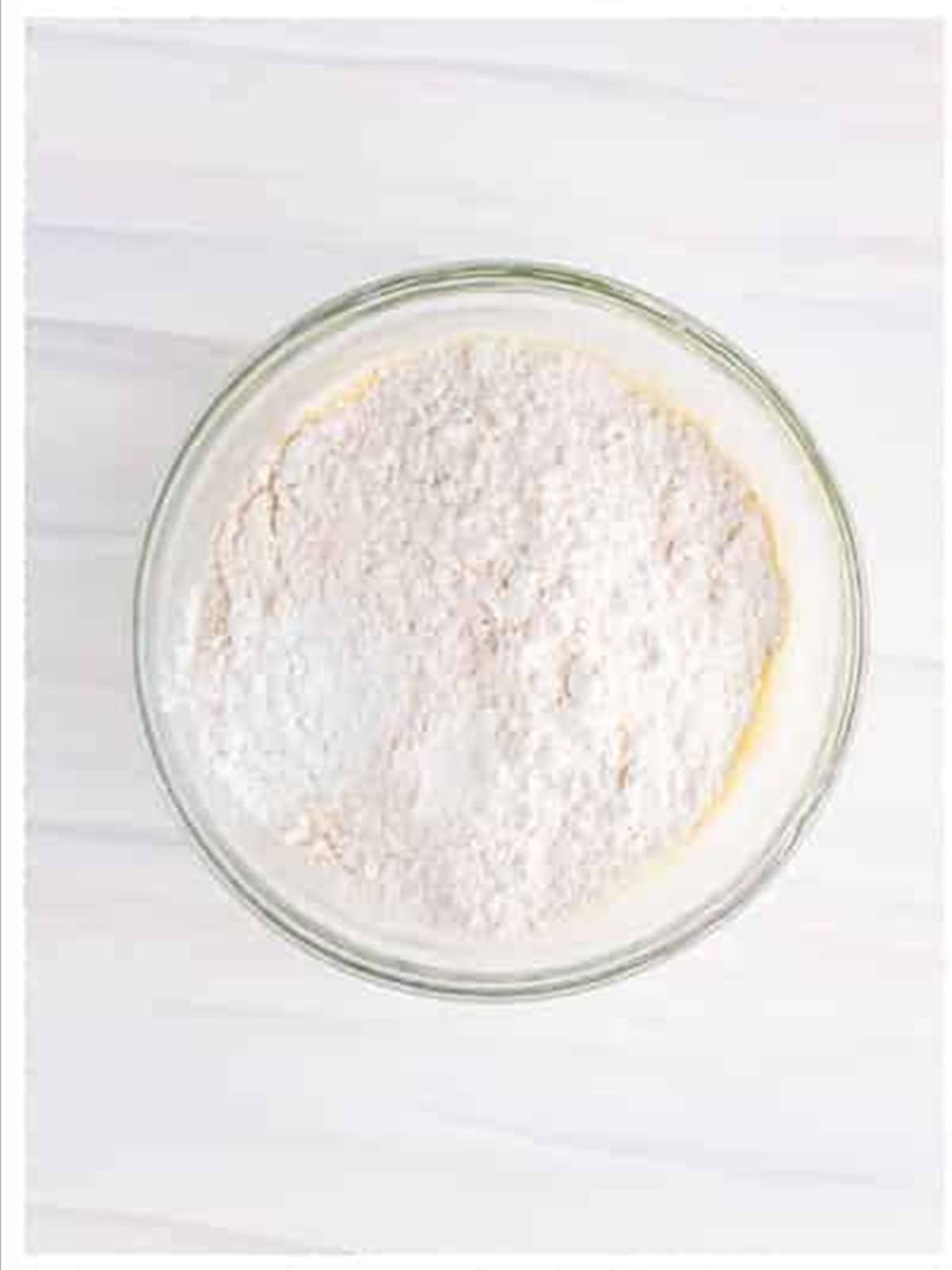 Adding flour, baking powder, and salt for funnel cake recipe.