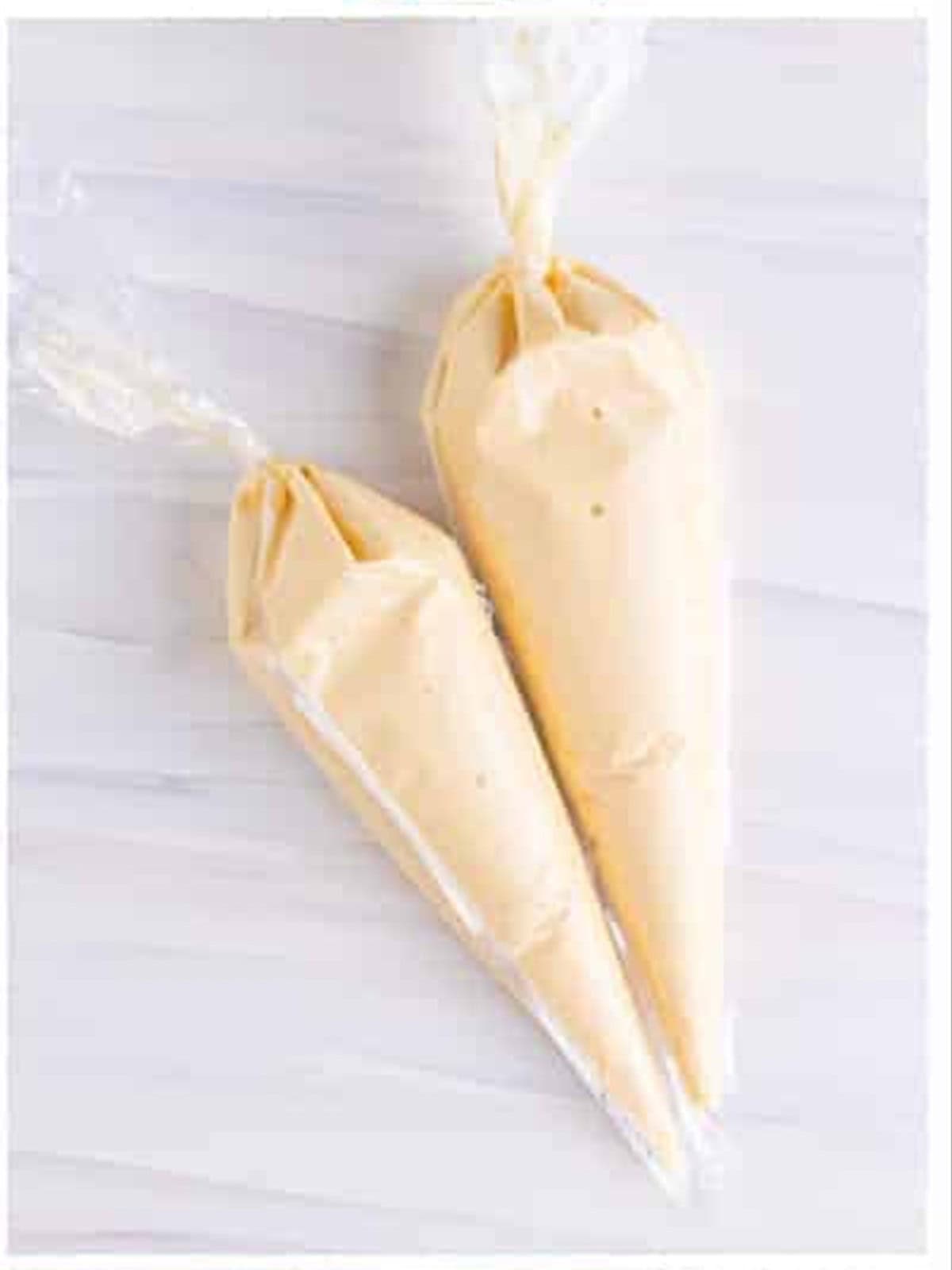 Funnel cake recipe batter divided between two piping bags.