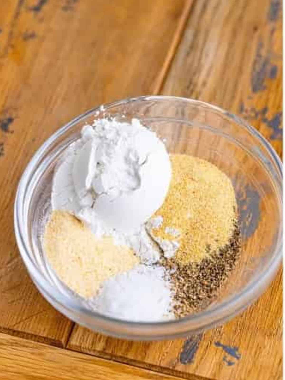 Mixing baking powder, garlic powder, onion powder, salt, and pepper in a bowl for Garlic Parmesan Wings.