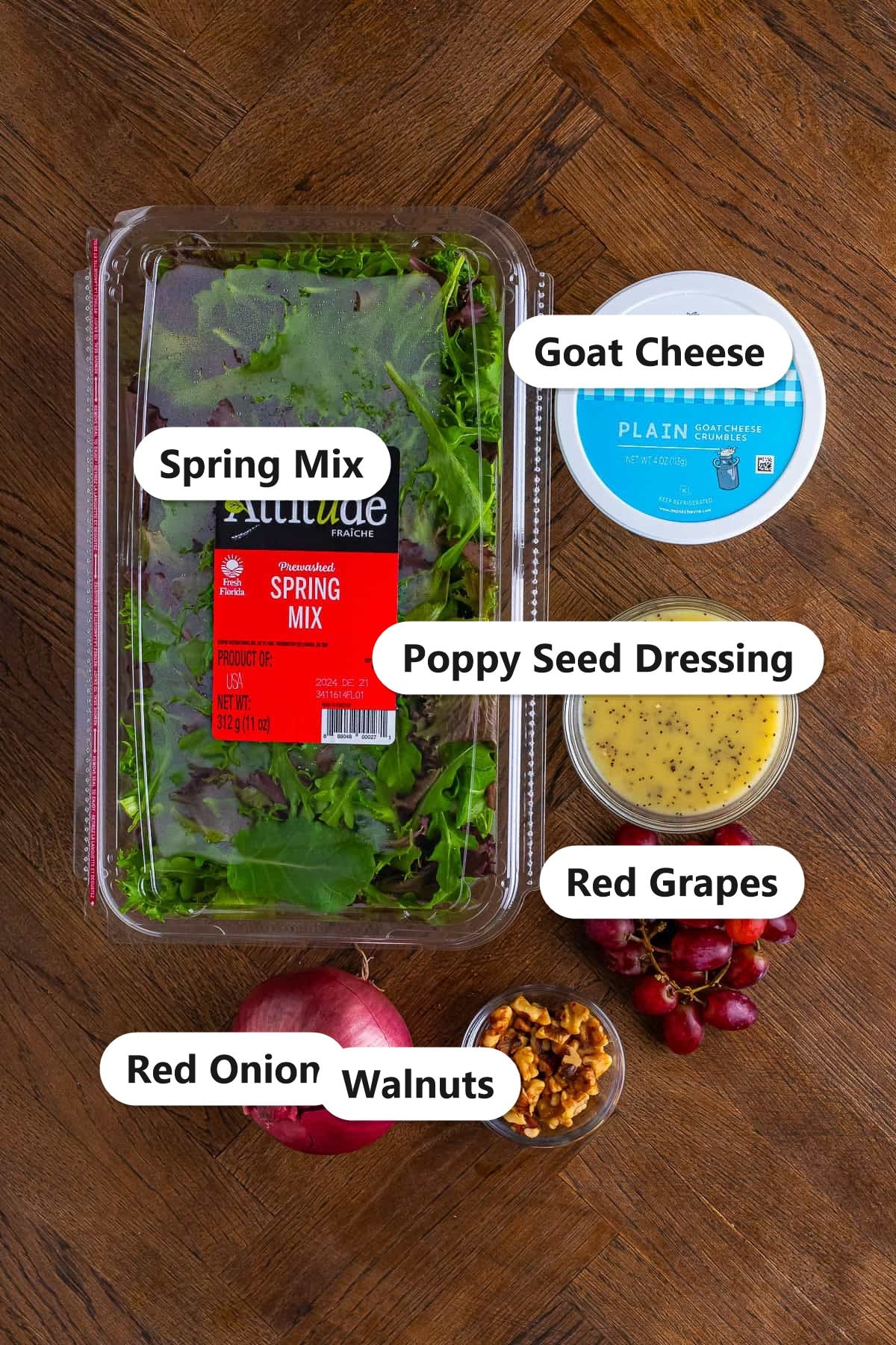 Labeled ingredients for goat cheese salad including spring mix, goat cheese, poppy seed dressing, red grapes, red onion, and walnuts.