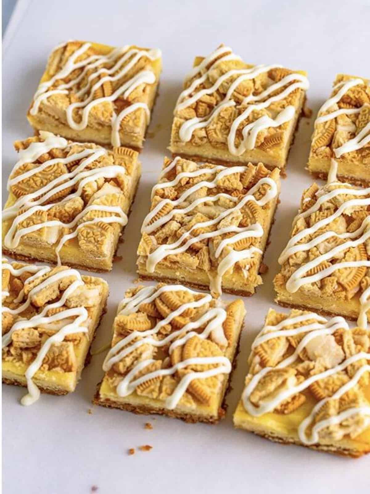 Golden Oreo cheesecake bars cut into squares and drizzled with white chocolate.