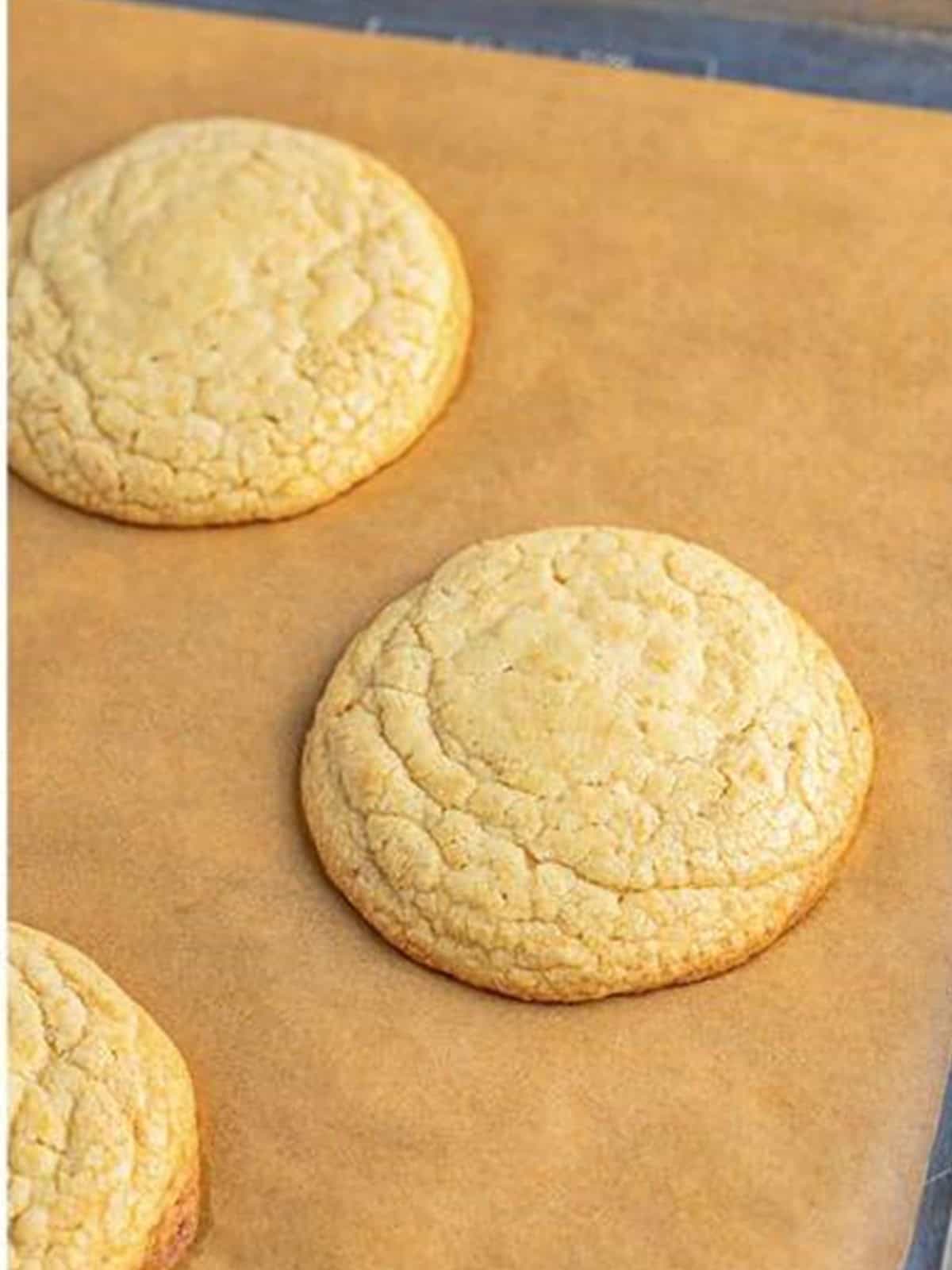 Baked golden Oreo cookies cooling on a parchment lined tray.