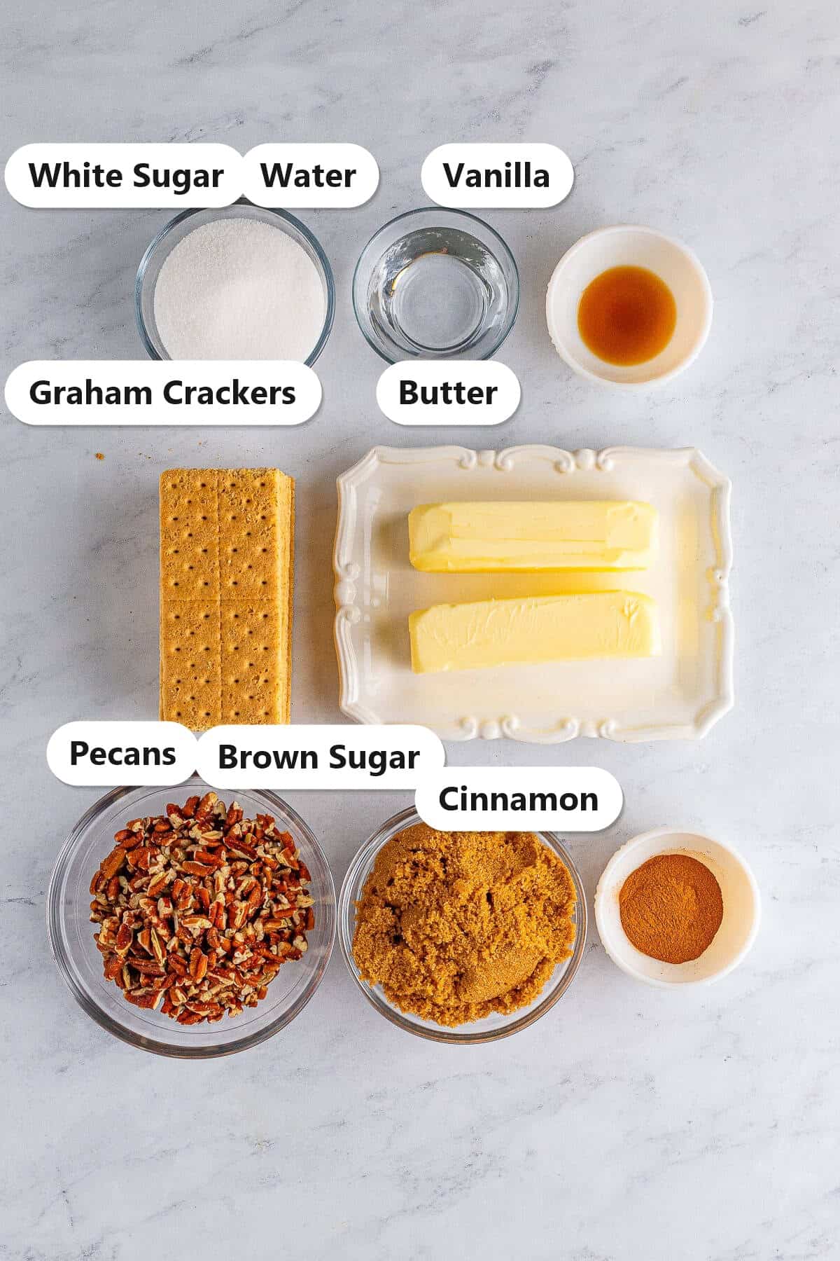 Labeled ingredients for graham cracker toffee including graham crackers, butter, brown sugar, pecans, cinnamon, sugar, water, and vanilla.