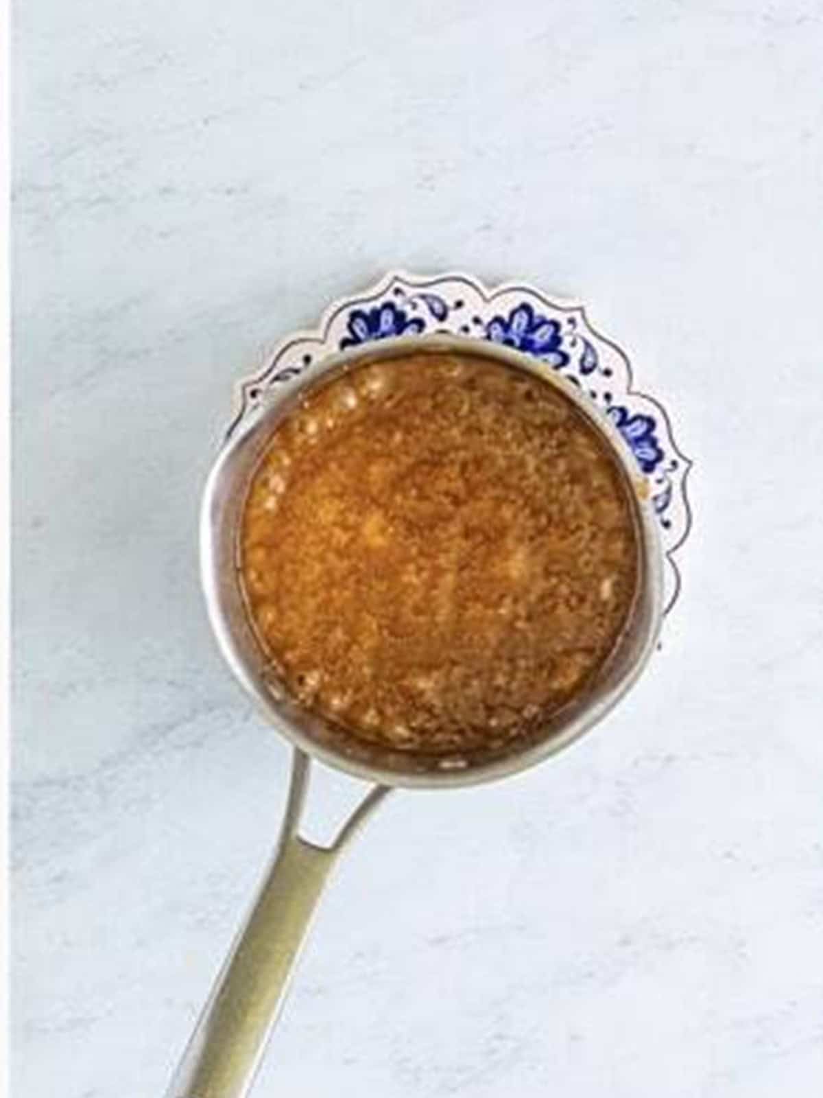 Butter and brown sugar boiling into a caramel in a saucepan.