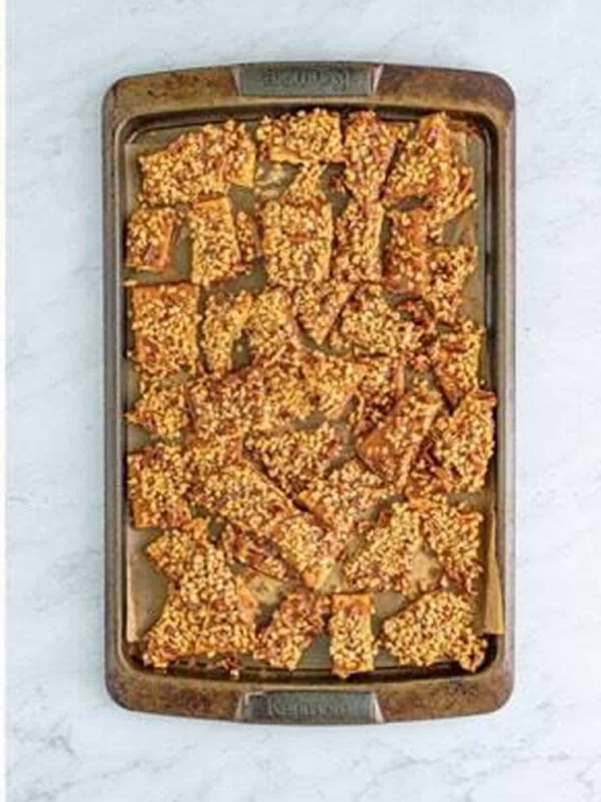 Graham cracker toffee broken into pieces on a baking sheet.