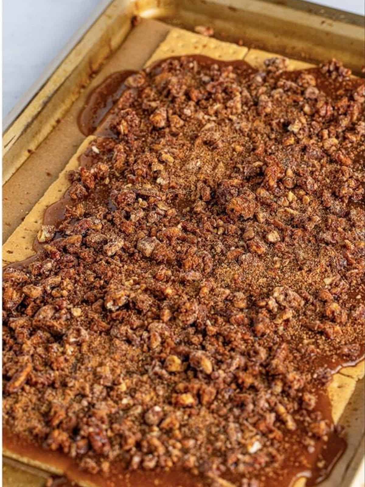 Hot toffee poured over the graham crackers on the tray.